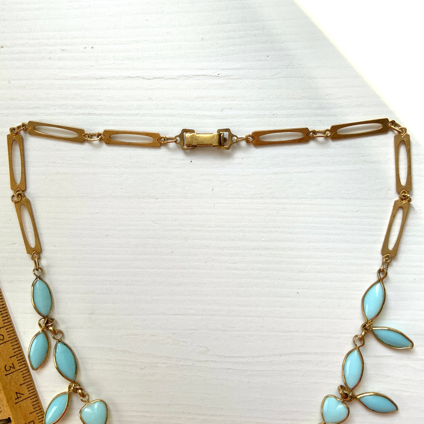 This necklace features a delicate chain of pale turquoise heart-shaped glass links, accented with marquise-shaped glass fringe. 淡いターコイズカラーのハートグラスチェーンに、マーキス 型のグラスのフリンジがついたネックレス。