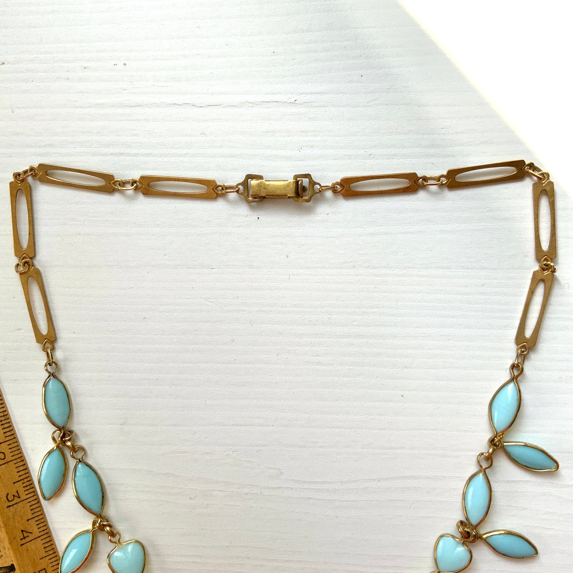 This necklace features a delicate chain of pale turquoise heart-shaped glass links, accented with marquise-shaped glass fringe. 淡いターコイズカラーのハートグラスチェーンに、マーキス 型のグラスのフリンジがついたネックレス。