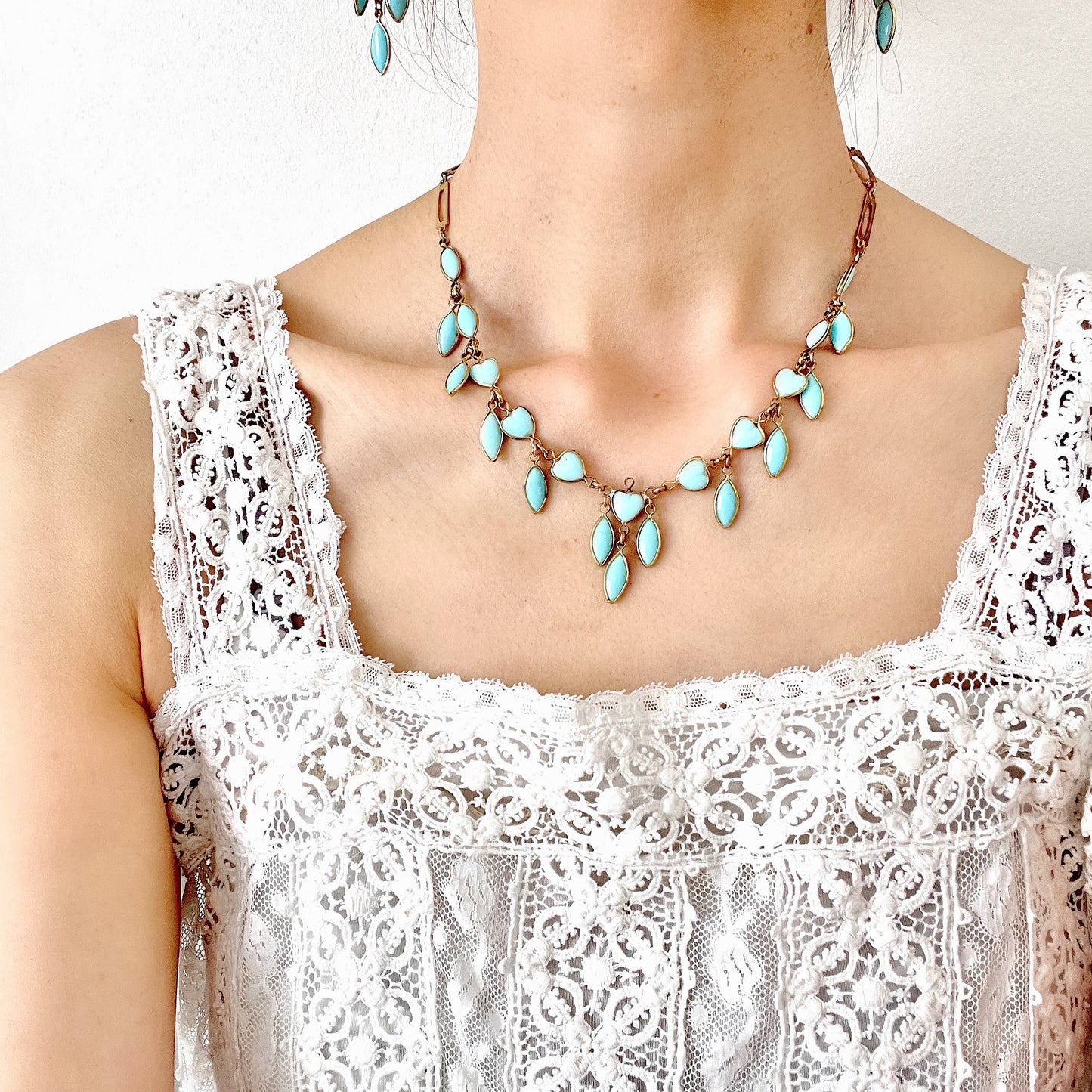 This necklace features a delicate chain of pale turquoise heart-shaped glass links, accented with marquise-shaped glass fringe. 淡いターコイズカラーのハートグラスチェーンに、マーキス 型のグラスのフリンジがついたネックレス。
