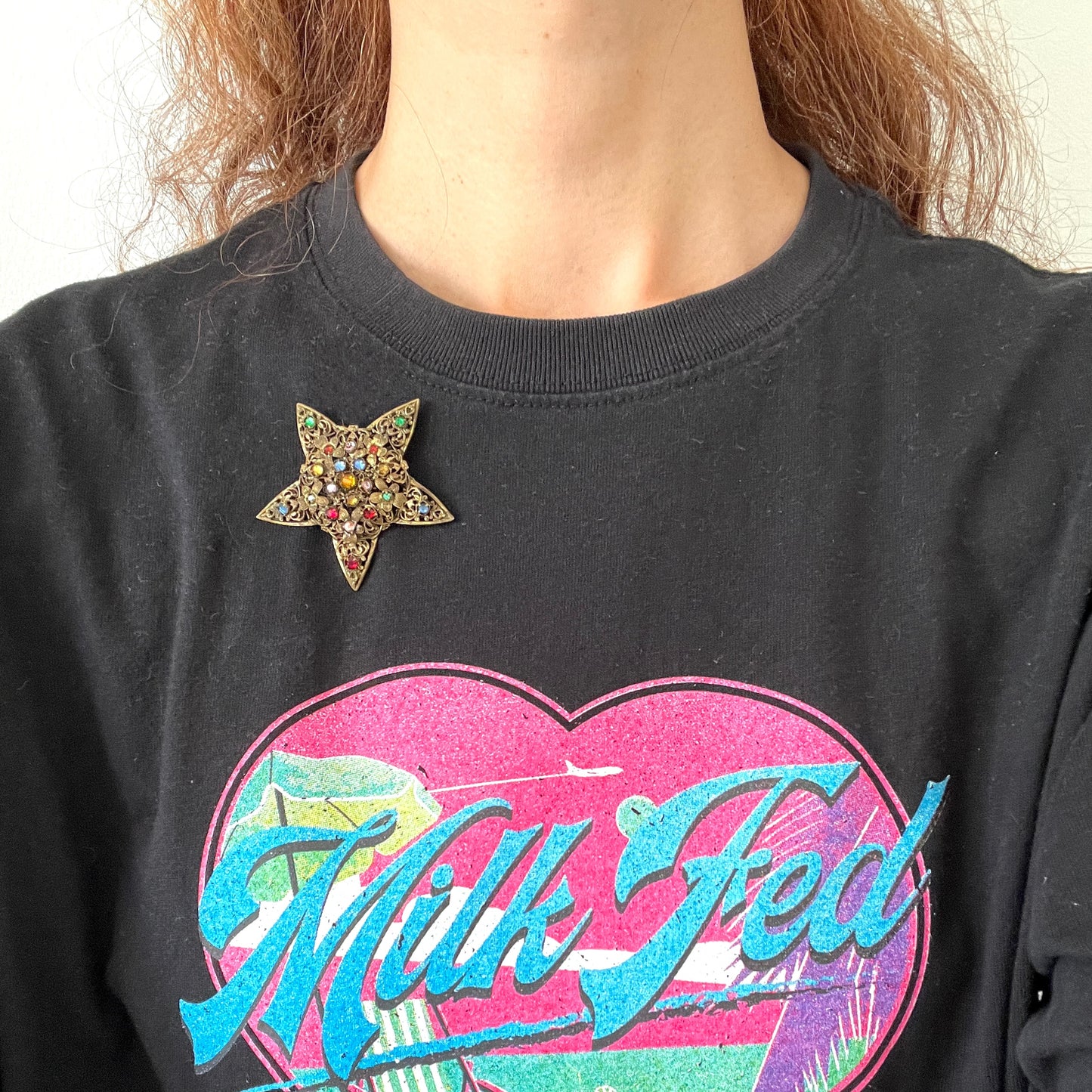 A beautiful vintage brooch featuring a star-shaped design crafted in intricate gold-tone filigree, adorned with multicoloured rhinestones. ゴールドトーンの繊細なフィリグリー細工でかたどられた星に、色とりどりのラインストーンがあしらわれたヴィンテージブローチ。