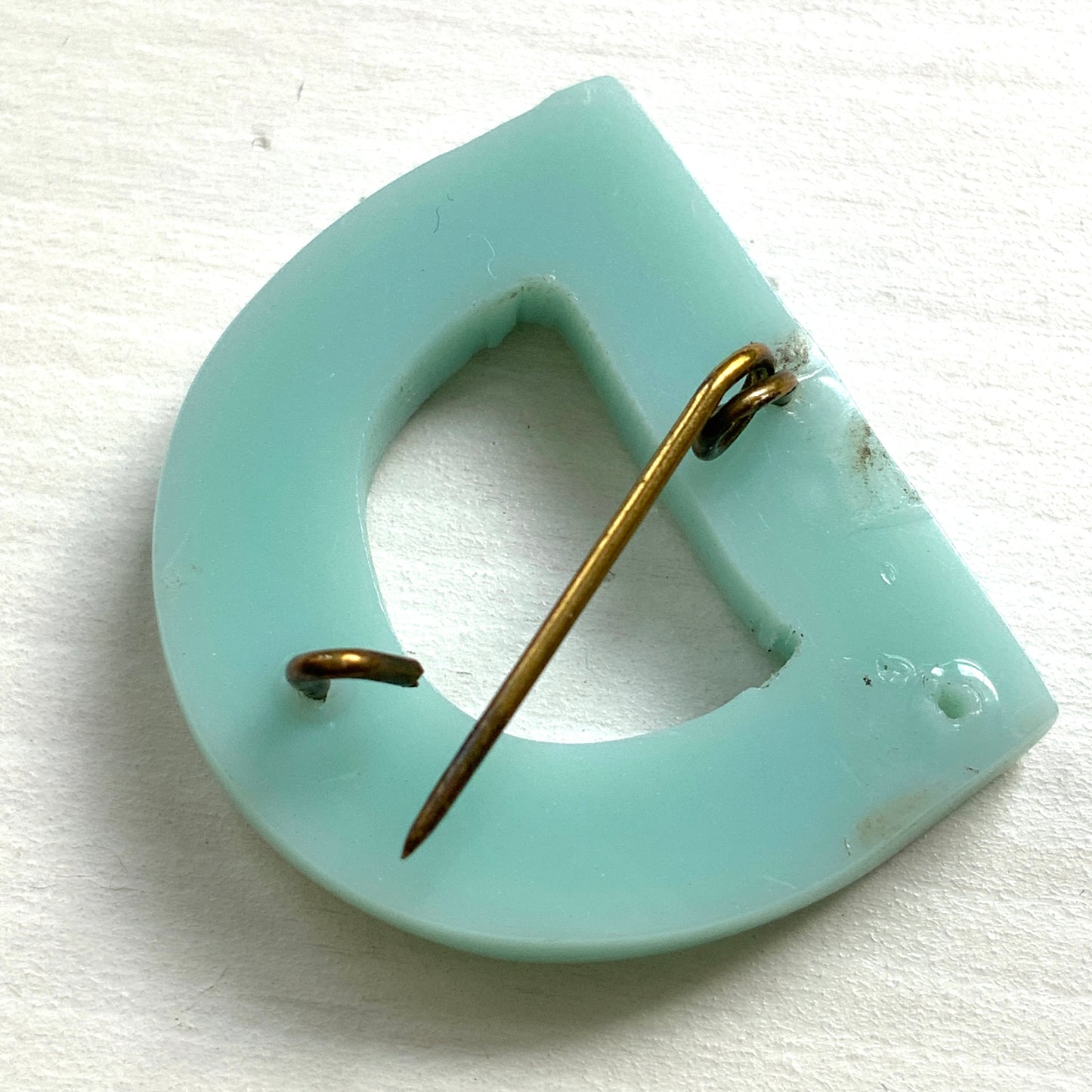 A brooch in the shape of the letter “D”, crafted from pale blue early plastic and adorned with colourful clay flowers. 淡い水色のアーリープラスチックに、カラフルなクレイのお花が咲いた”D"のブローチ。