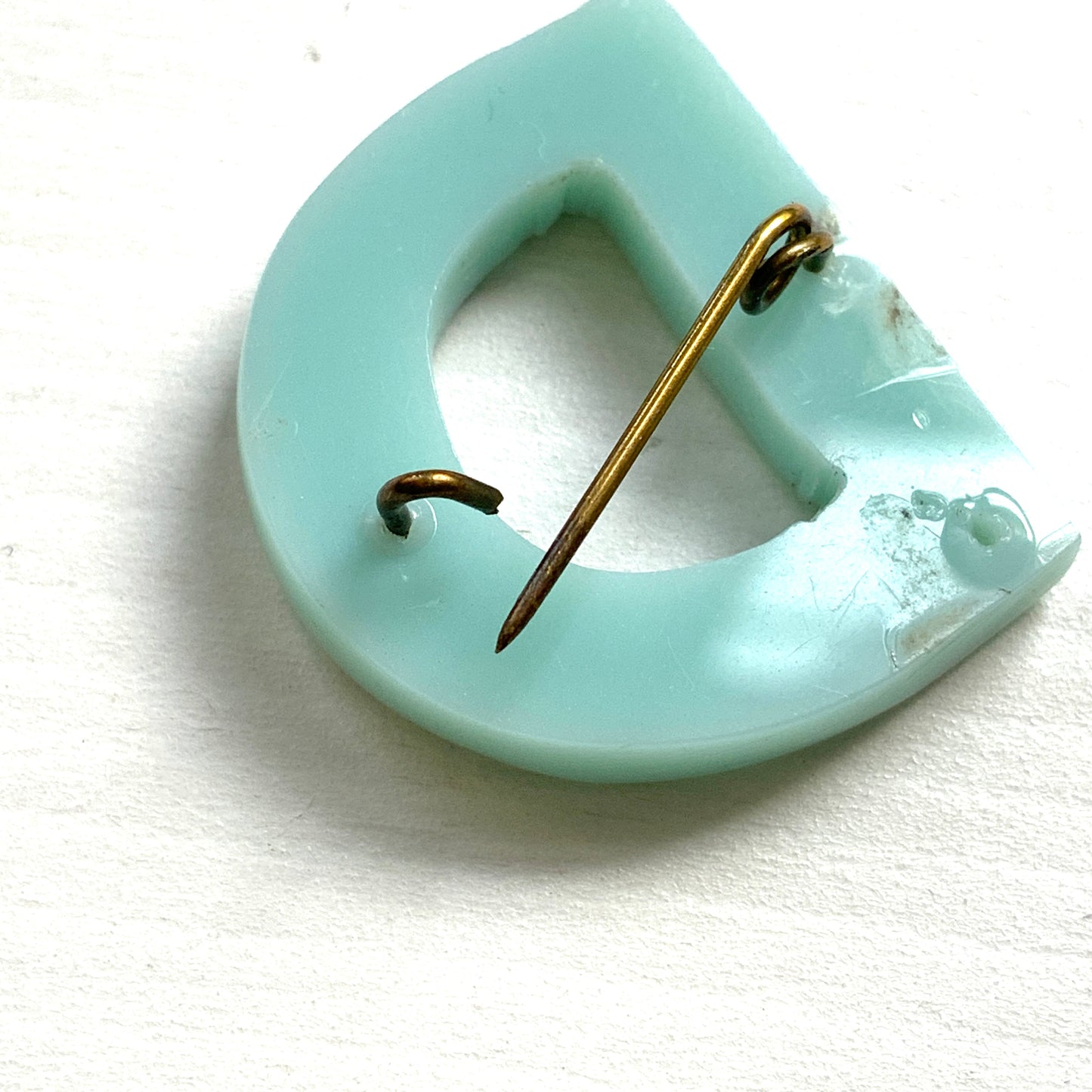 A brooch in the shape of the letter “D”, crafted from pale blue early plastic and adorned with colourful clay flowers. 淡い水色のアーリープラスチックに、カラフルなクレイのお花が咲いた”D"のブローチ。