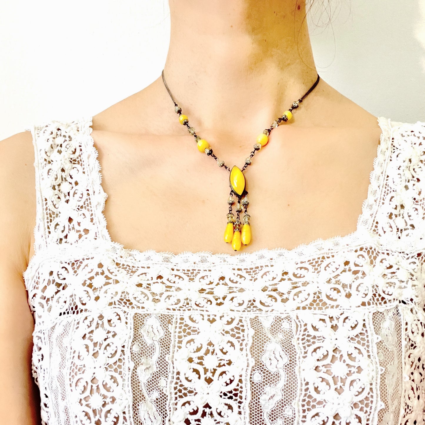A 1930s necklace featuring soft butterscotch yellow satin glass, paired with delicate filigree details and clear glass accents. やわらかなバタースコッチイエローのサテンガラスに、繊細なフィリグリーパーツとクリアガラスを合わせた1930年代頃のネックレス。