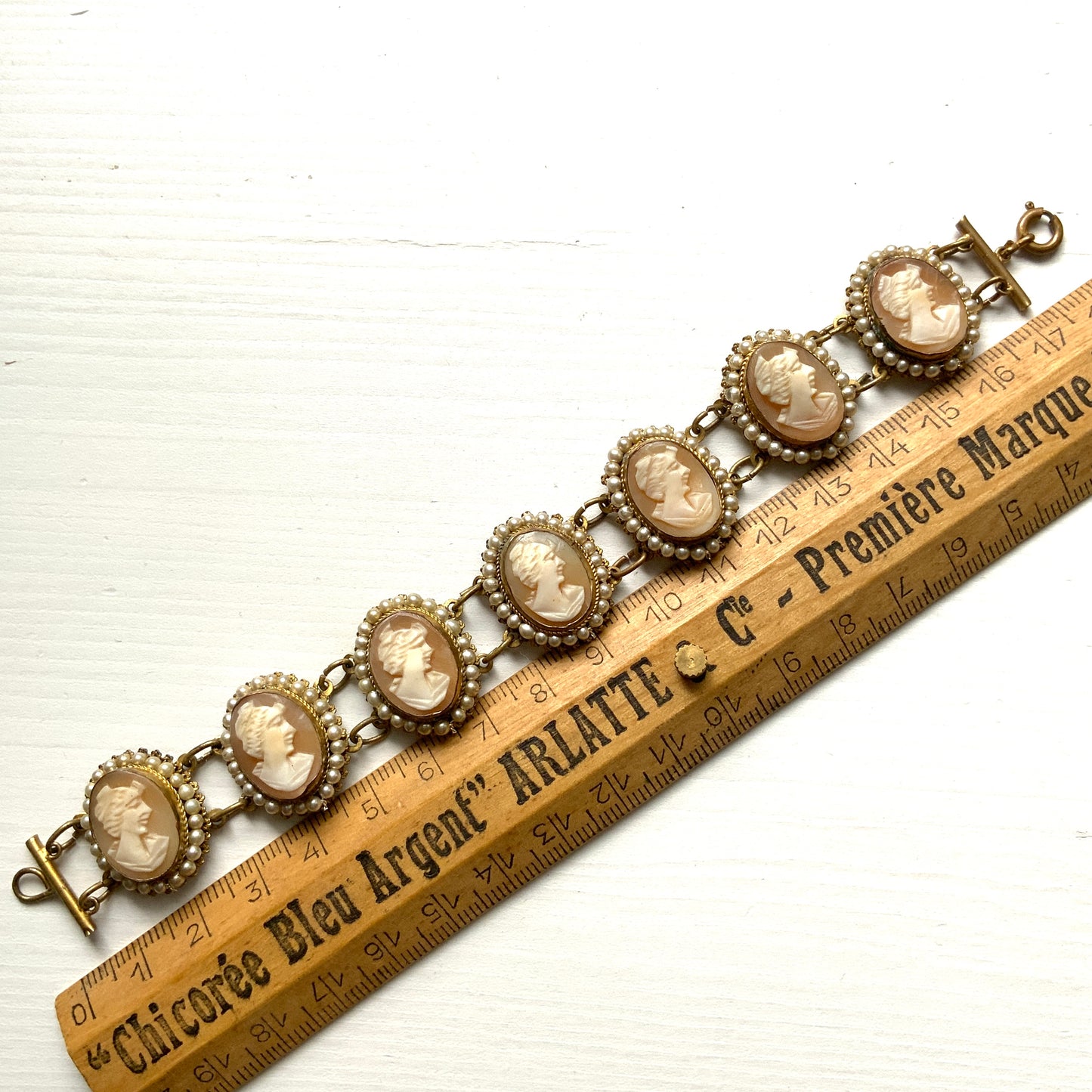 A bracelet lavishly set with seven shell cameos, each delicately framed with tiny glass pearls. 七つのシェルカメオを贅沢に連ねたブレスレット。