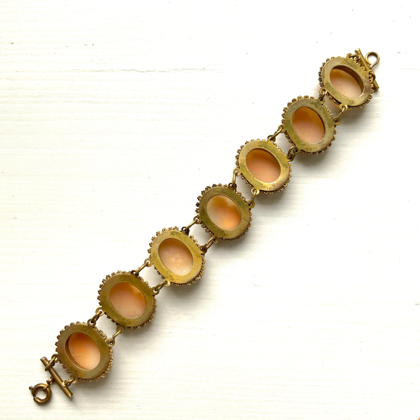 A bracelet lavishly set with seven shell cameos, each delicately framed with tiny glass pearls. 七つのシェルカメオを贅沢に連ねたブレスレット。