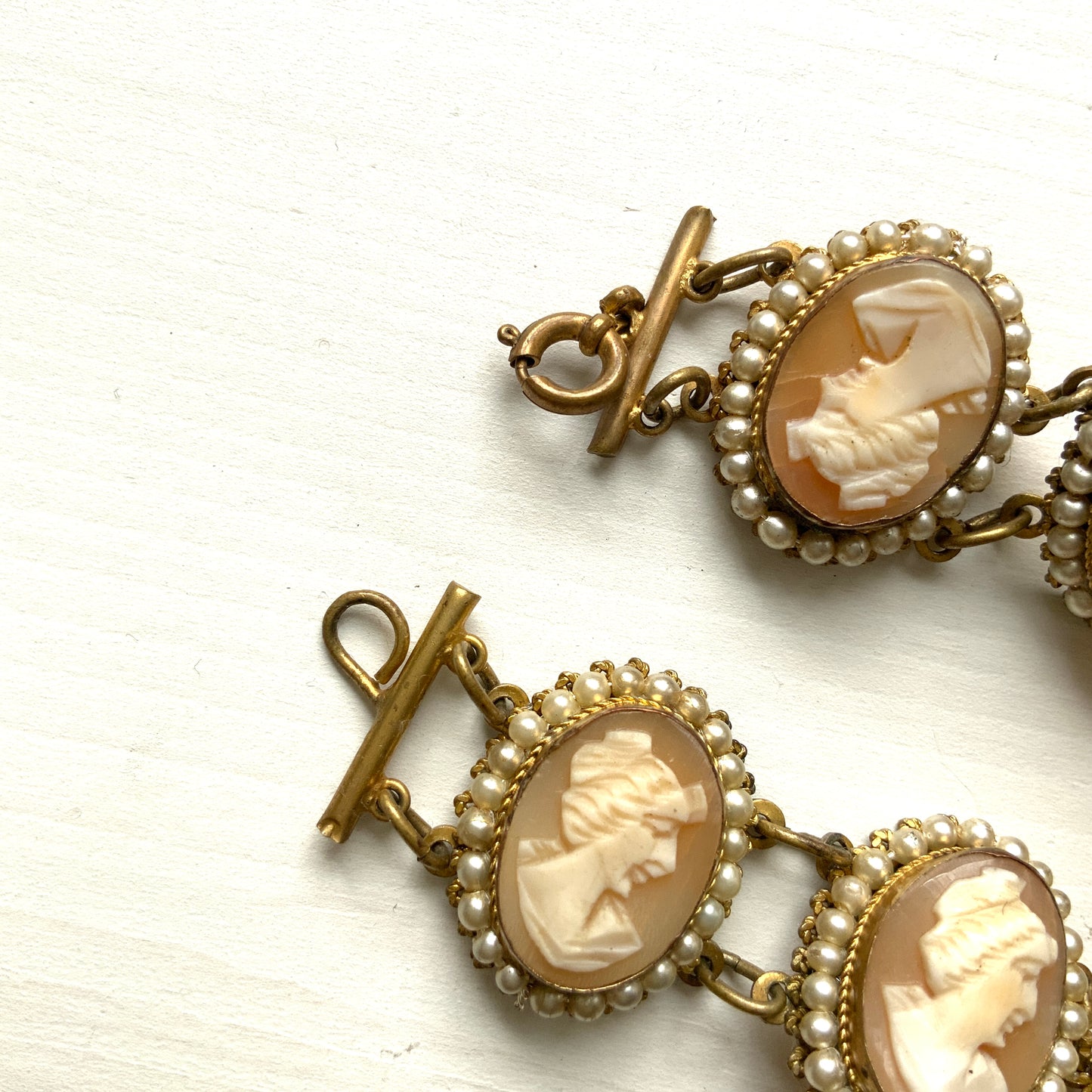 A bracelet lavishly set with seven shell cameos, each delicately framed with tiny glass pearls. 七つのシェルカメオを贅沢に連ねたブレスレット。