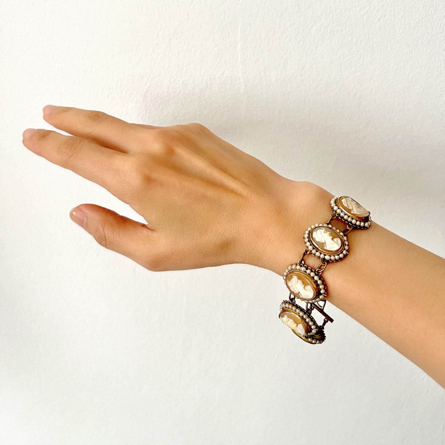 A bracelet lavishly set with seven shell cameos, each delicately framed with tiny glass pearls. 七つのシェルカメオを贅沢に連ねたブレスレット。
