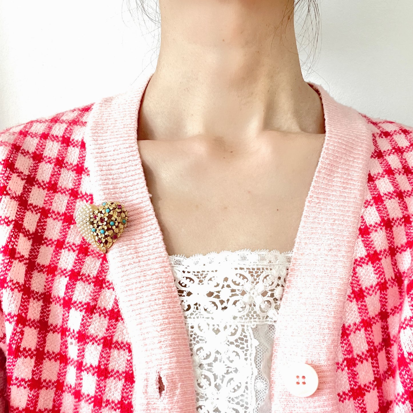 A gold-tone heart brooch featuring delicate floral motifs and seed pearls. ゴールドトーンのお花とシードパールを組み合わせた、ハートモチーフのブローチ。