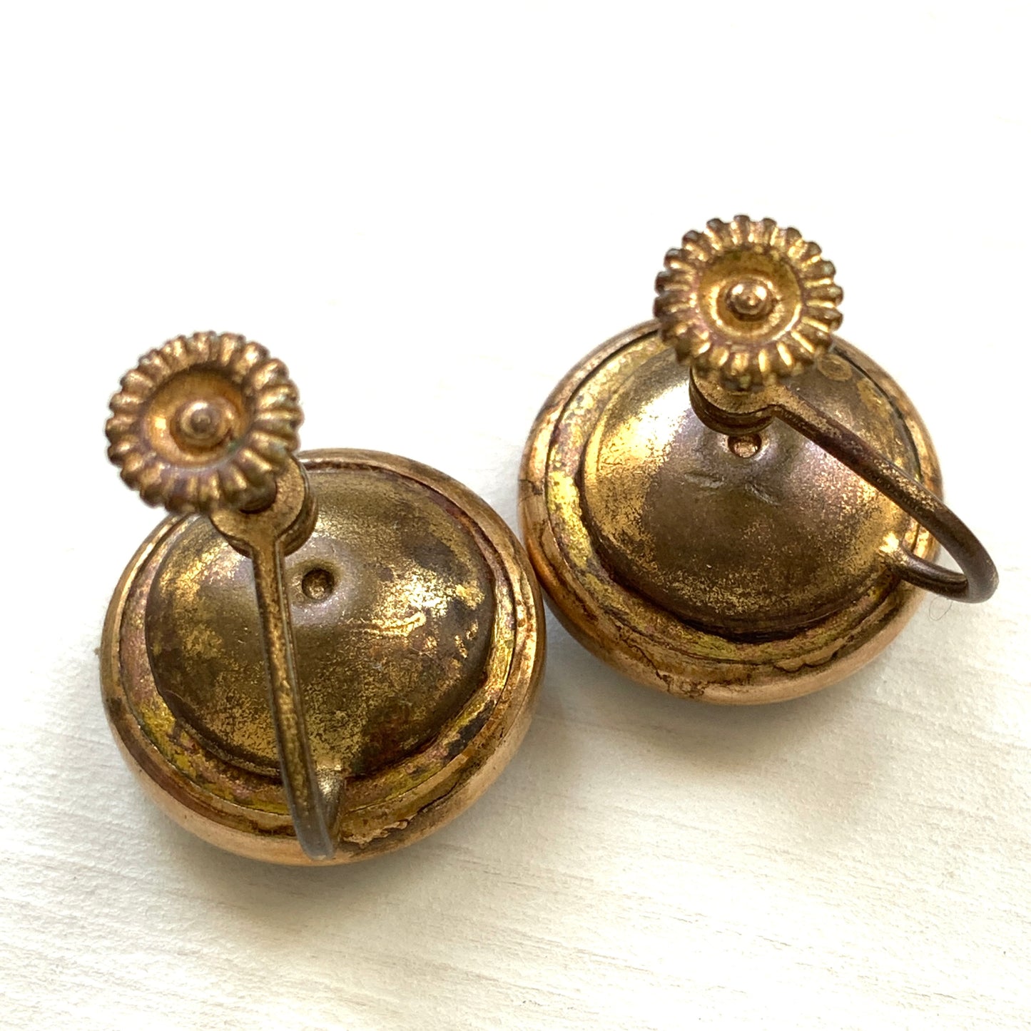Screw-back earrings featuring an reverse carved design of a Taurus bull . 黒地にゴールドトーンで牡牛とそのシンボルが裏彫りされた、ヴィンテージのスクリューイヤリング。