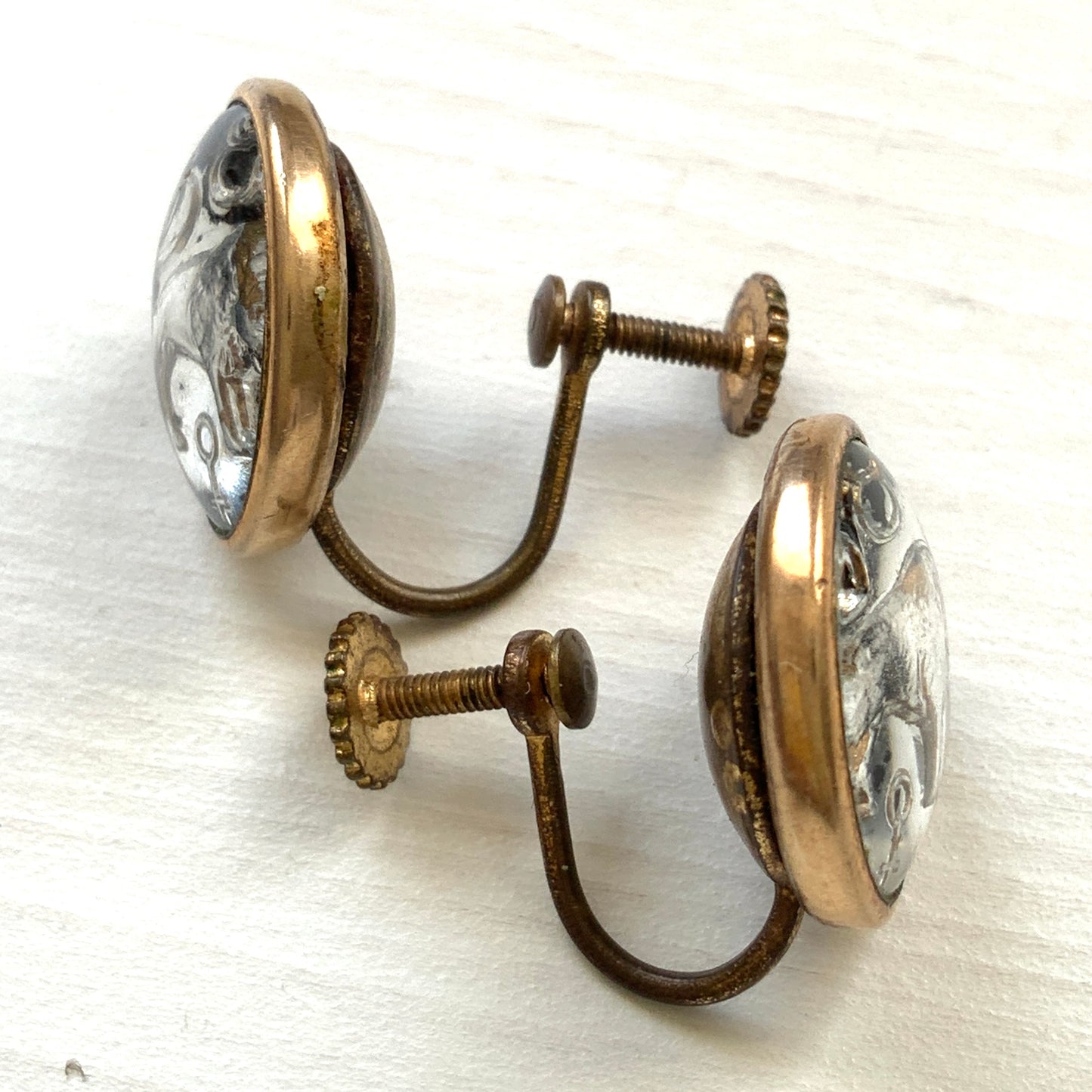 Screw-back earrings featuring an reverse carved design of a Taurus bull . 黒地にゴールドトーンで牡牛とそのシンボルが裏彫りされた、ヴィンテージのスクリューイヤリング。
