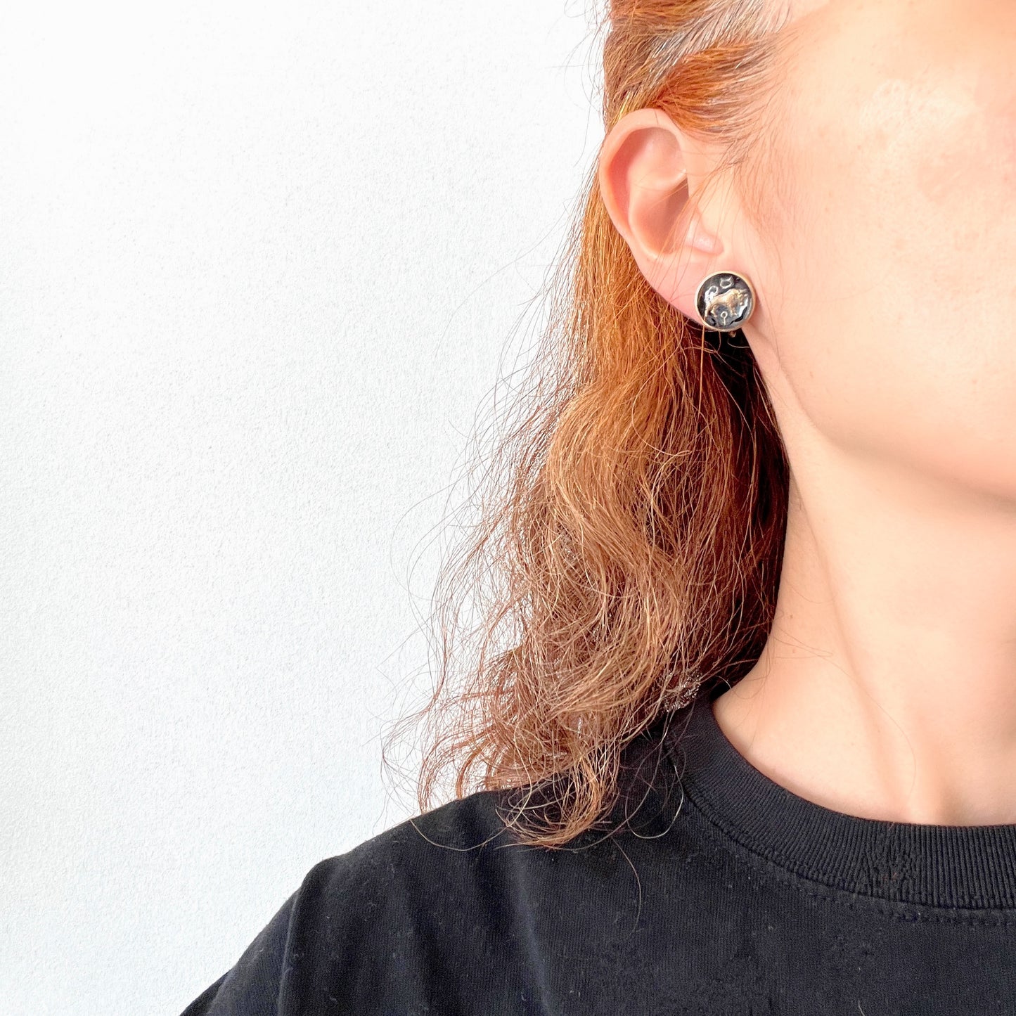 Screw-back earrings featuring an reverse carved design of a Taurus bull . 黒地にゴールドトーンで牡牛とそのシンボルが裏彫りされた、ヴィンテージのスクリューイヤリング。