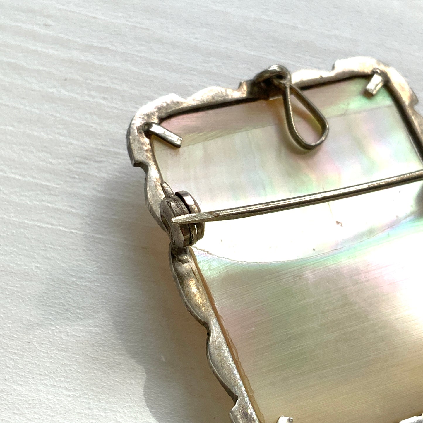 A brooch featuring a cameo of a lady’s profile carved in black mother of pearl, set against a white mother of pearl base. 白蝶貝をベースに、黒蝶貝で女性の横顔カメオをあしらったブローチ。