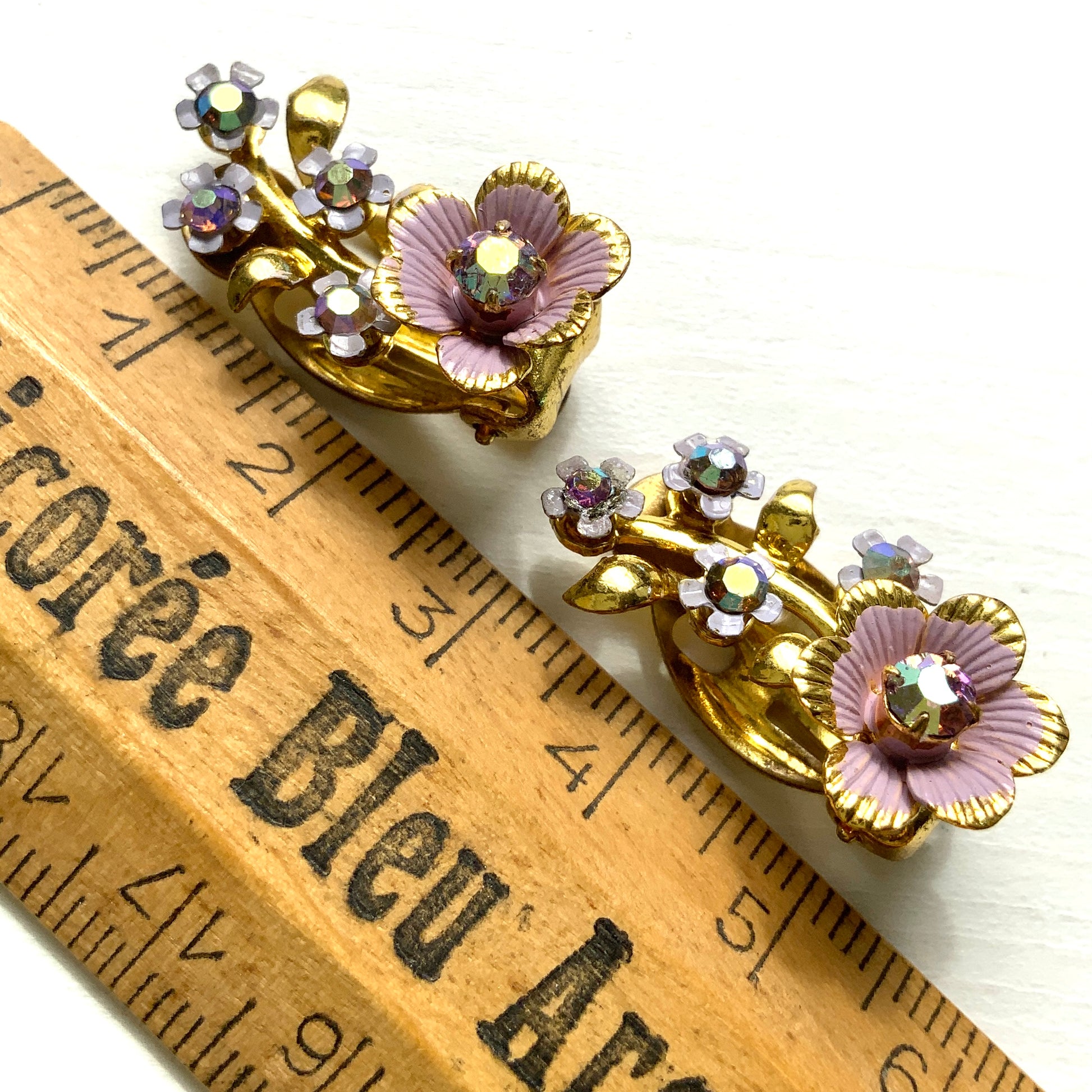 These are charming clip-on earrings featuring small flowers decorated with lilac-coloured enamel.かわいらしいライラックカラーのエナメルで彩られた、小さなお花のクリップイヤリング。
