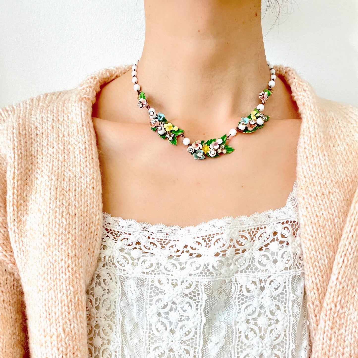 A vintage necklace featuring pastel-coloured flowers and milk glass beads. パステルカラーの花とミルクグラスビーズが連なった、ヴィンテージネックレス。