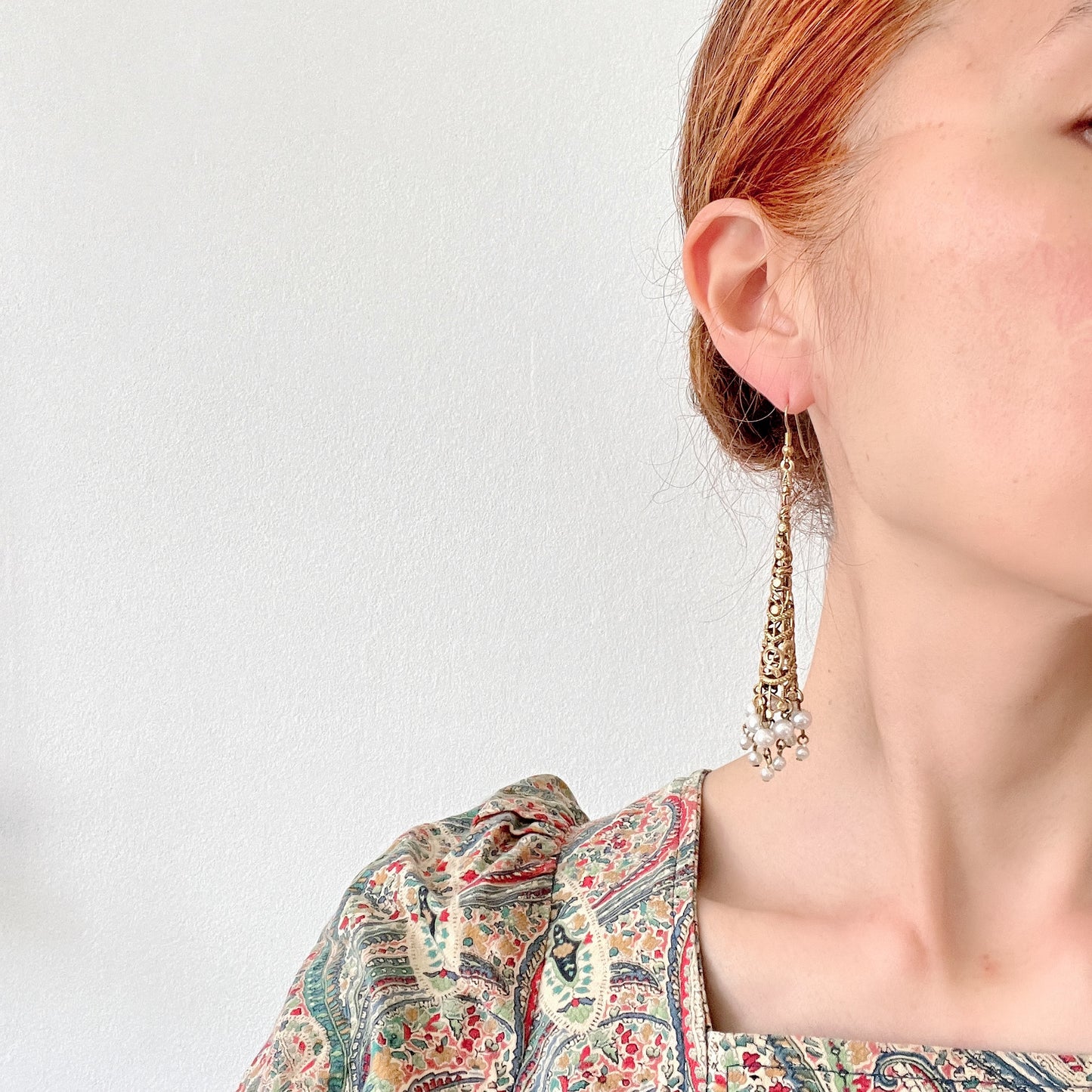 These earrings feature gold-tone filigree cones with faux pearl fringes that dangle elegantly. ゴールドトーンのフィリグリーのコーンにフォーパールのフリンジが揺れるピアス。