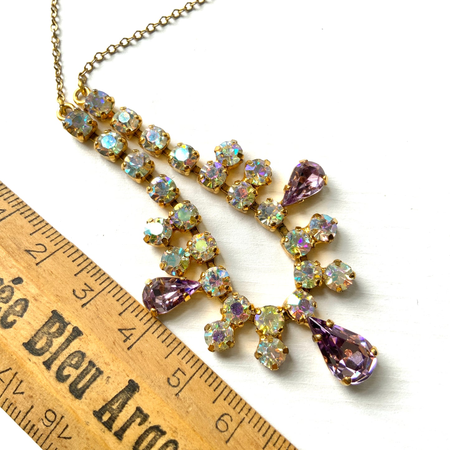 A necklace featuring white aurora borealis, accented with lilac-coloured teardrop rhinestones. ホワイトのオーロラストーンに、ライラックカラーのティアドロップラインストーン がアクセントになったネックレス。