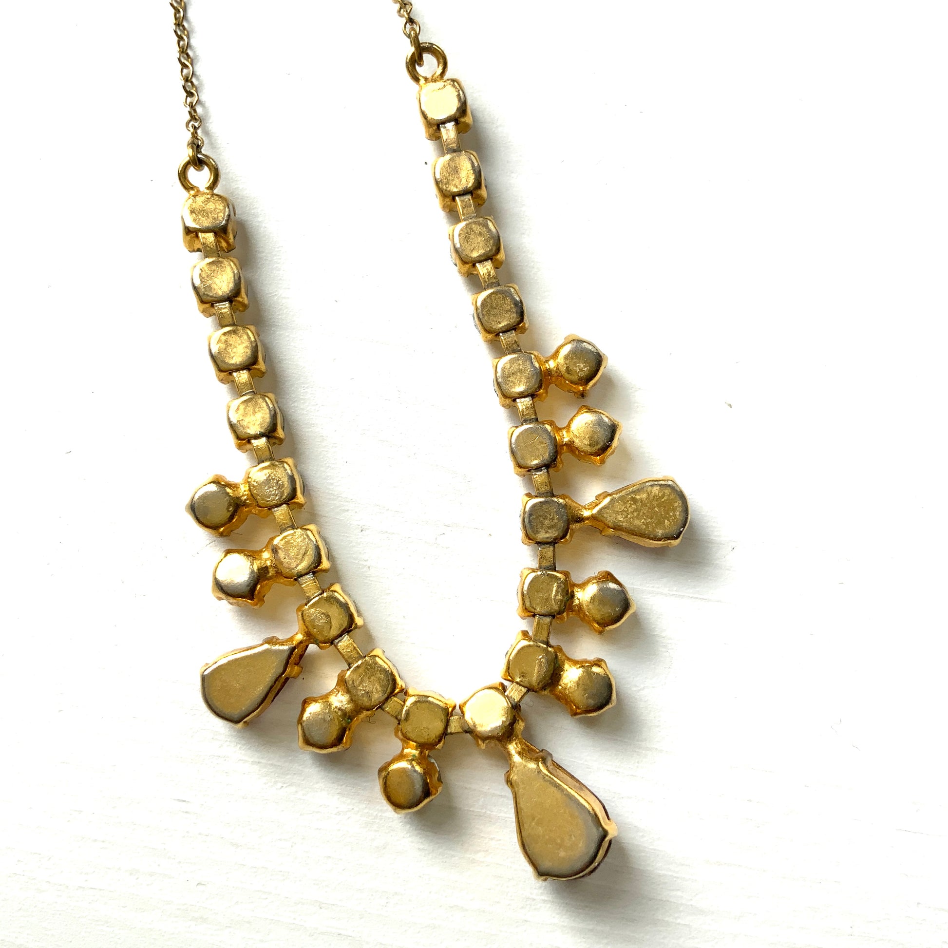 A necklace featuring white aurora borealis, accented with lilac-coloured teardrop rhinestones. ホワイトのオーロラストーンに、ライラックカラーのティアドロップラインストーン がアクセントになったネックレス。