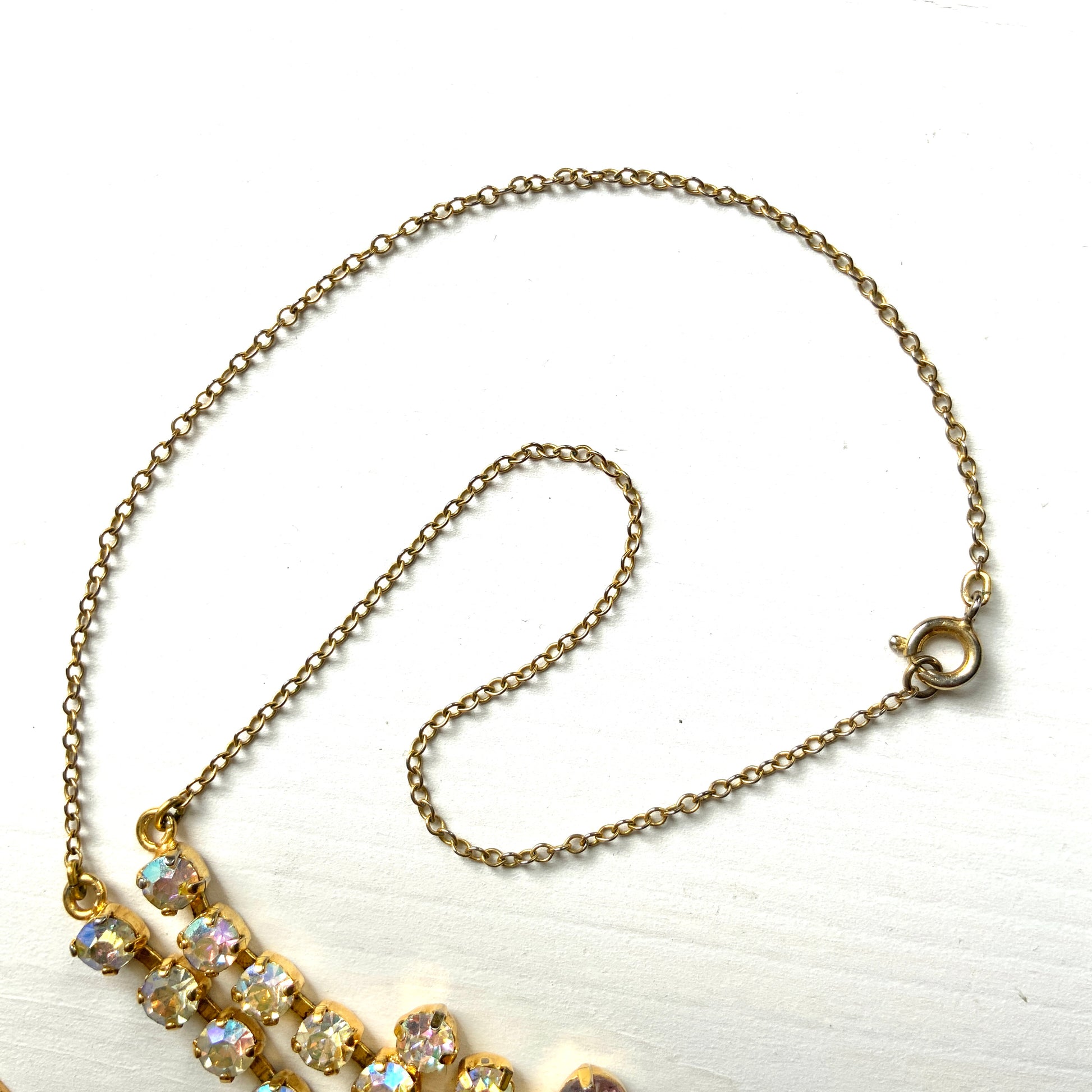 A necklace featuring white aurora borealis, accented with lilac-coloured teardrop rhinestones. ホワイトのオーロラストーンに、ライラックカラーのティアドロップラインストーン がアクセントになったネックレス。