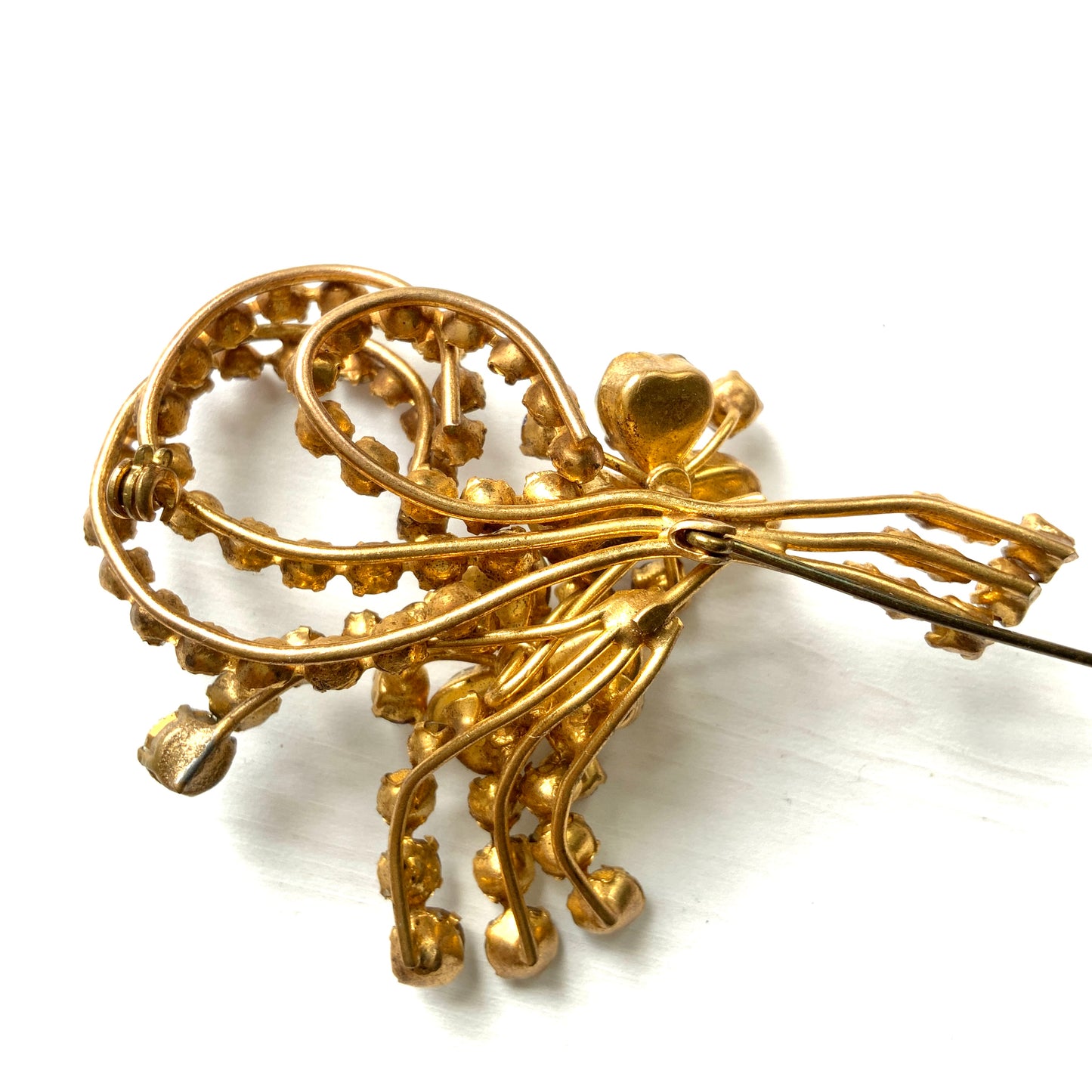 A gorgeous brooch featuring clear and lilac-colored rhinestones.  クリアカラーとライラックカラーのラインストーンのゴージャスなブローチ。