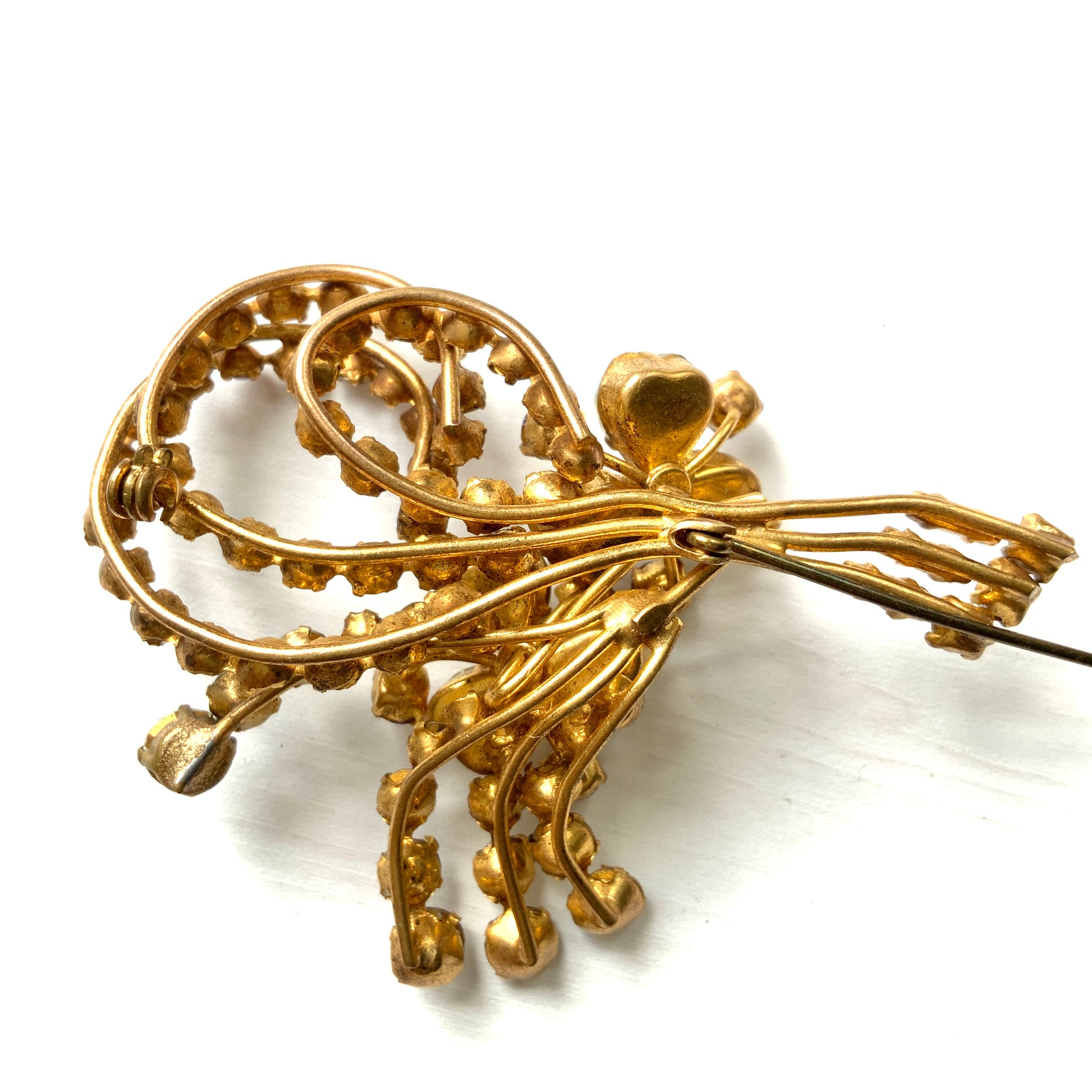 A gorgeous brooch featuring clear and lilac-colored rhinestones.  クリアカラーとライラックカラーのラインストーンのゴージャスなブローチ。