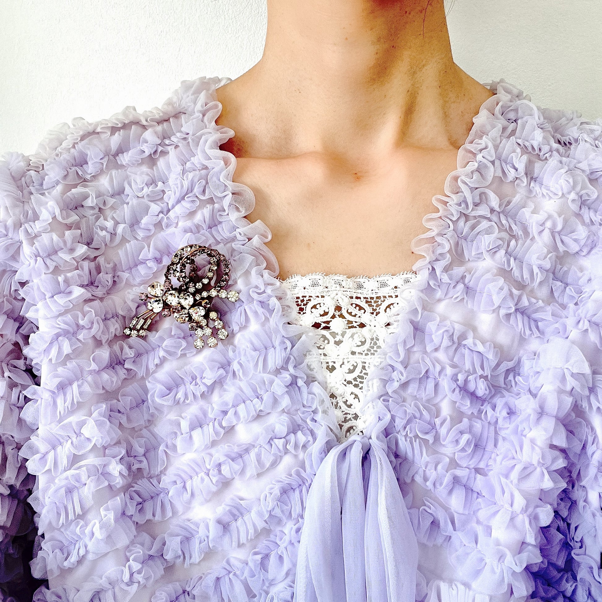 A gorgeous brooch featuring clear and lilac-colored rhinestones.  クリアカラーとライラックカラーのラインストーンのゴージャスなブローチ。