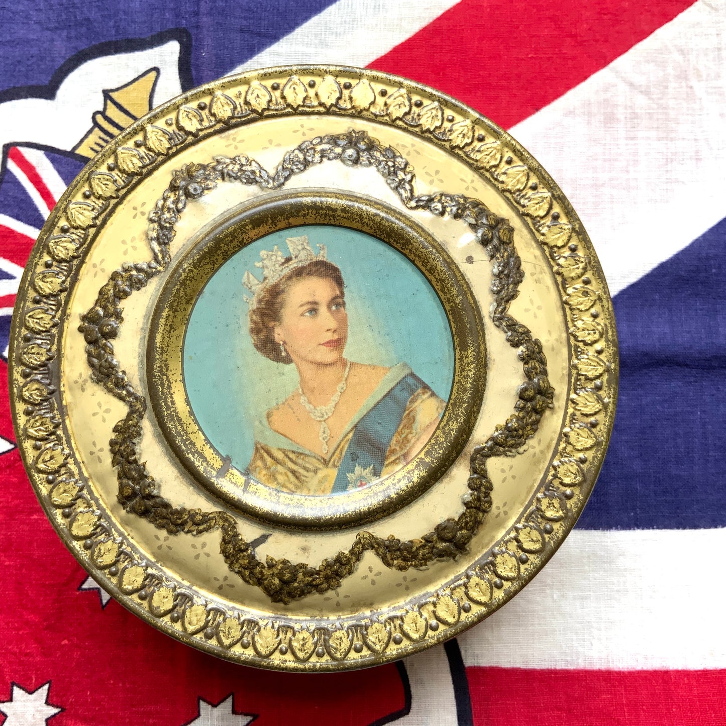 A commemorative tin from Meltis, a confectionery company known for chocolates, celebrating Queen Elizabeth’s coronation. チョコレートなどを製造するメルティス社の、エリザベス女王戴冠記念ティン缶。