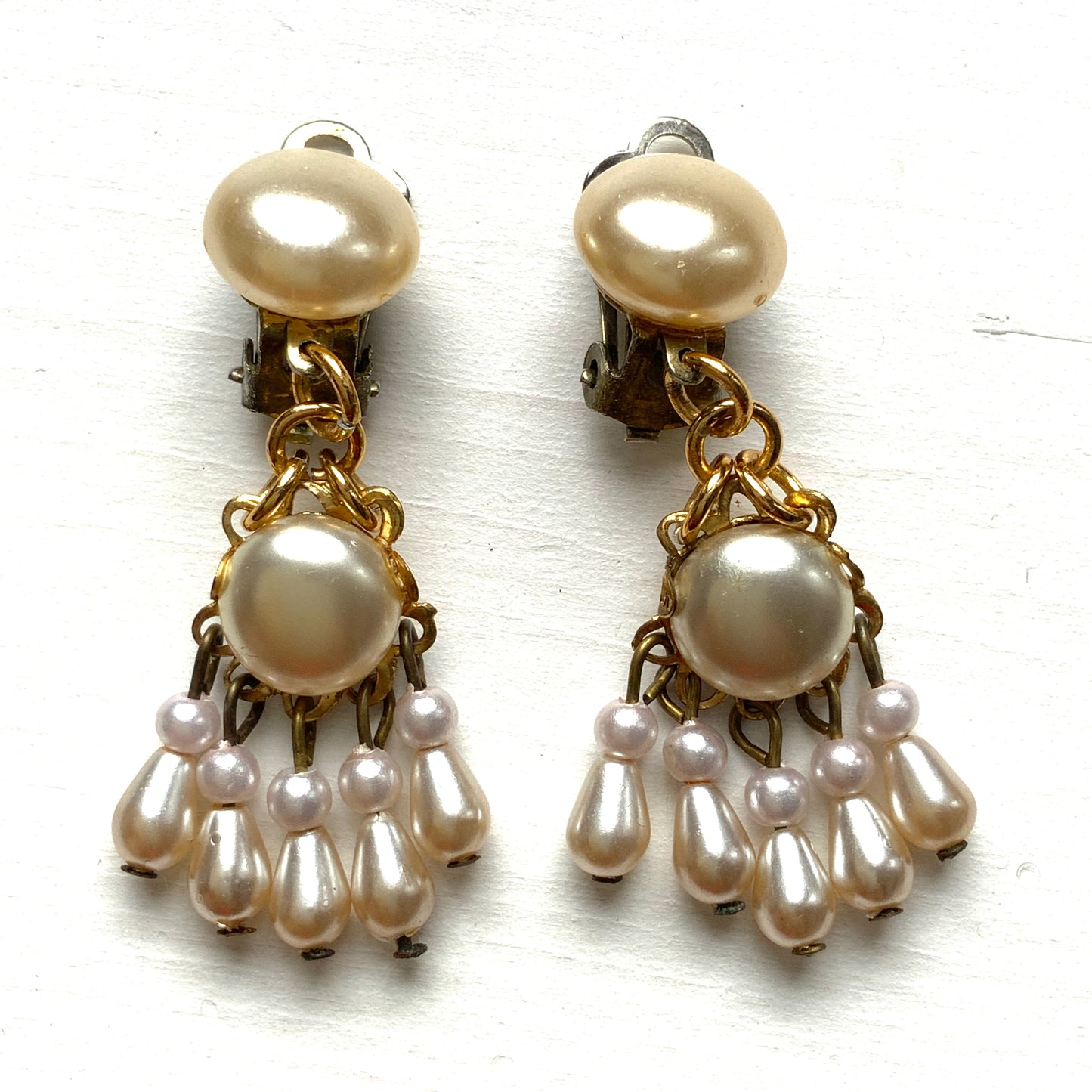 Clip earrings featuring button-shaped faux pearls with a fringe of many teardrop pearls. ボタン型フォーパールにたくさんのティアドロップパールのフリンジが揺れるクリップイヤリング。