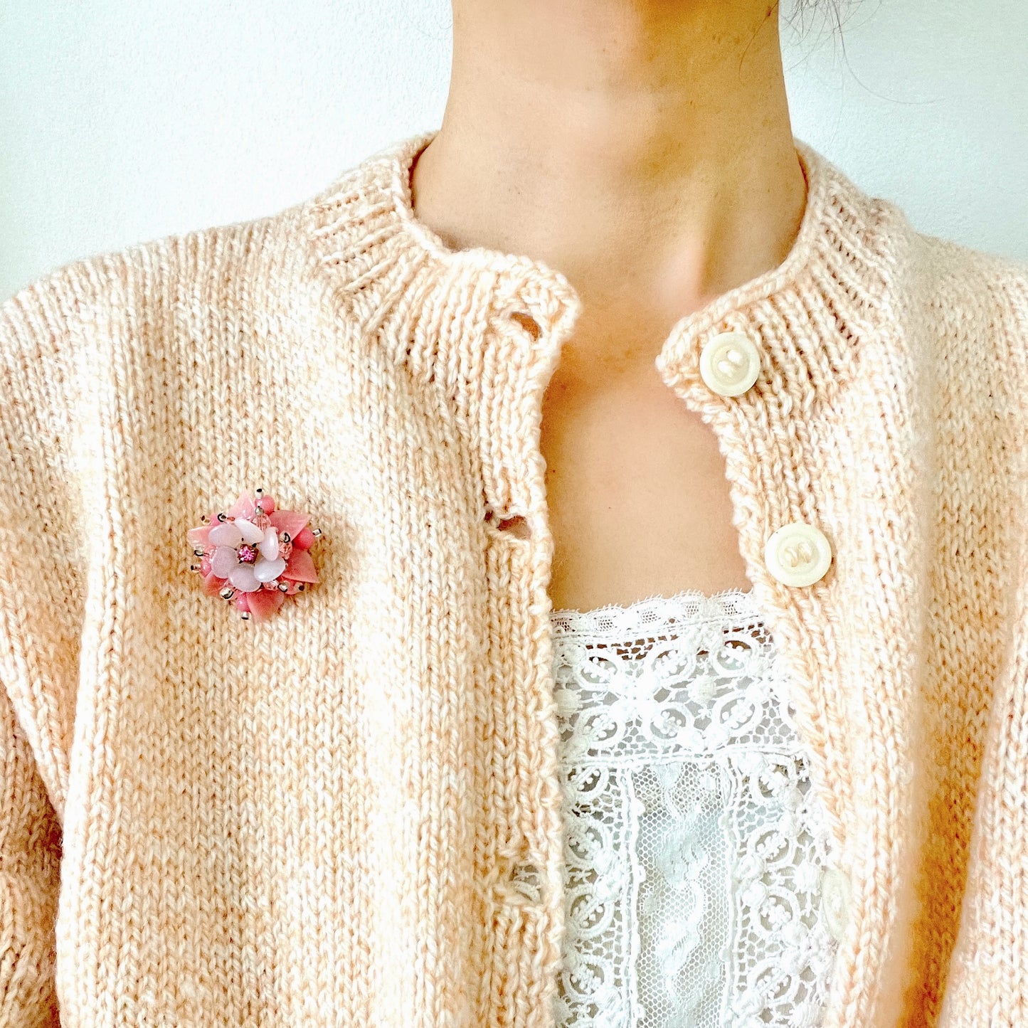 A floral brooch combining frosted glass, rhinestones, crystal beads and plastic elements. フロストガラスやラインストーン、クリスタルビーズ、プラスチックなど、異なる素材を組み合わせたフラワーブローチ。