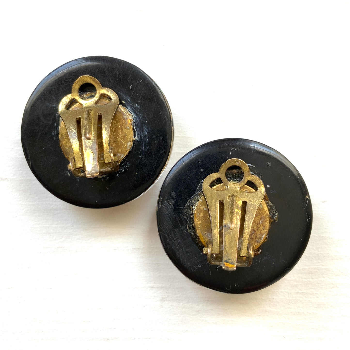 Clip-on earrings featuring a dome of black plastic filled with colourful star-shaped confetti. カラフルな星型コンフェッティが閉じ込められた、プラスチックドームのクリップイヤリング。