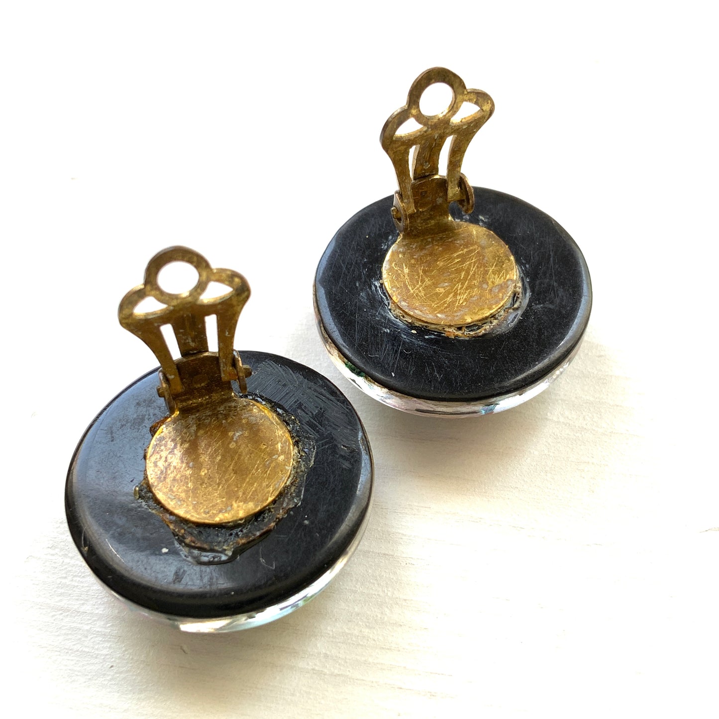Clip-on earrings featuring a dome of black plastic filled with colourful star-shaped confetti. カラフルな星型コンフェッティが閉じ込められた、プラスチックドームのクリップイヤリング。