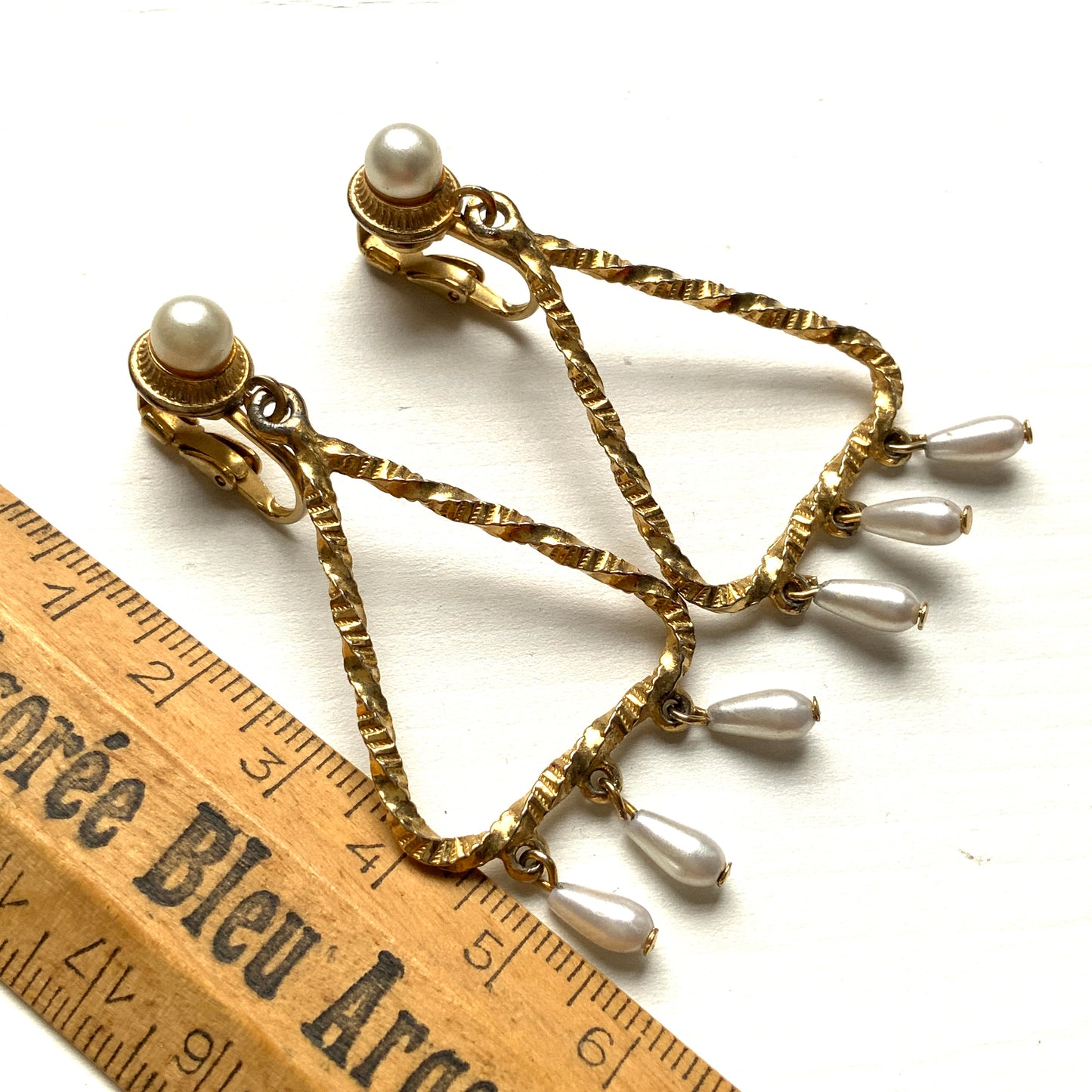 Gold-tone triangular frames with delicate teardrop pearl fringe clips. ゴールドトーンのトライアングル