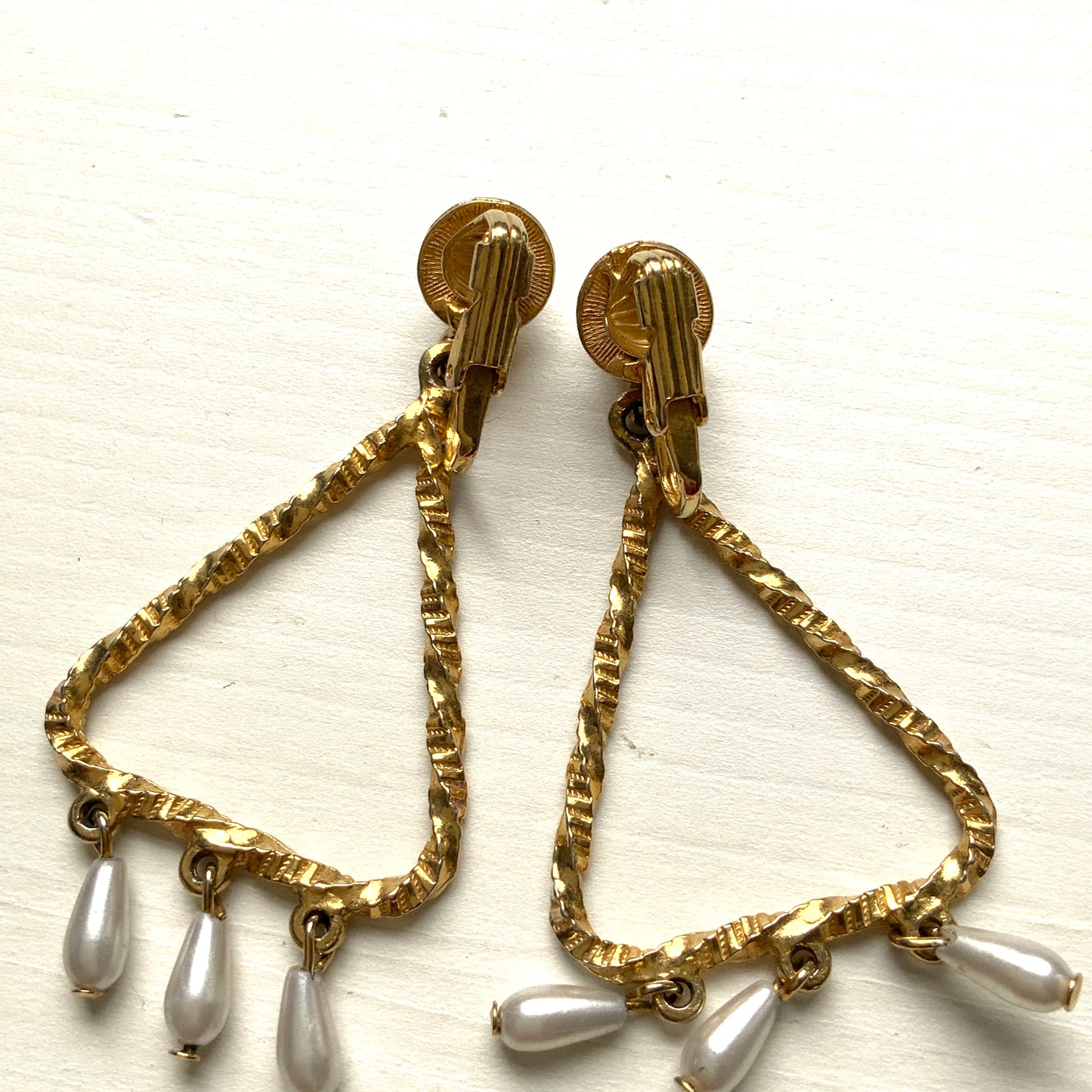 Gold-tone triangular frames with delicate teardrop pearl fringe clips. ゴールドトーンのトライアングル