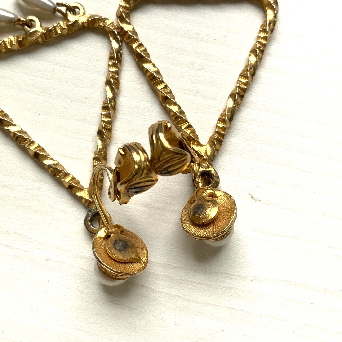 Gold-tone triangular frames with delicate teardrop pearl fringe clips. ゴールドトーンのトライアングル