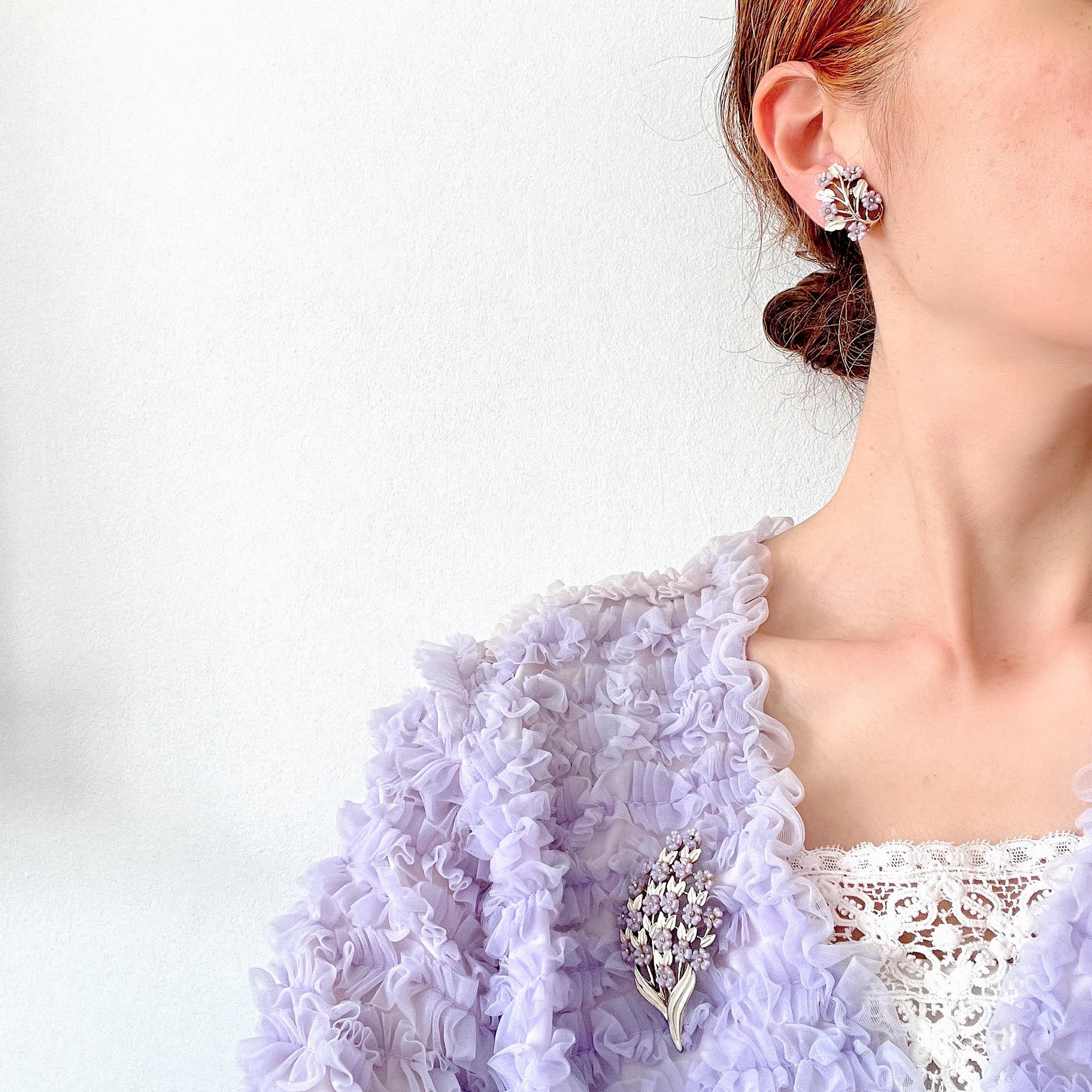 Charming clip-on earrings with pale purple blossoms adorning white enameled leaves. 白いエナメルの葉っぱに、かわいらしい薄紫のお花が咲いたクリップイヤリング。