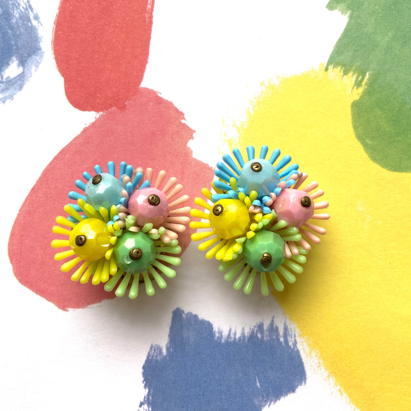 Clip-on earrings featuring clusters of soft plastic flowers in colourful candy hues. カラフルなキャンディーカラーのソフトプラスチックのお花が集まったクリップイヤリング。