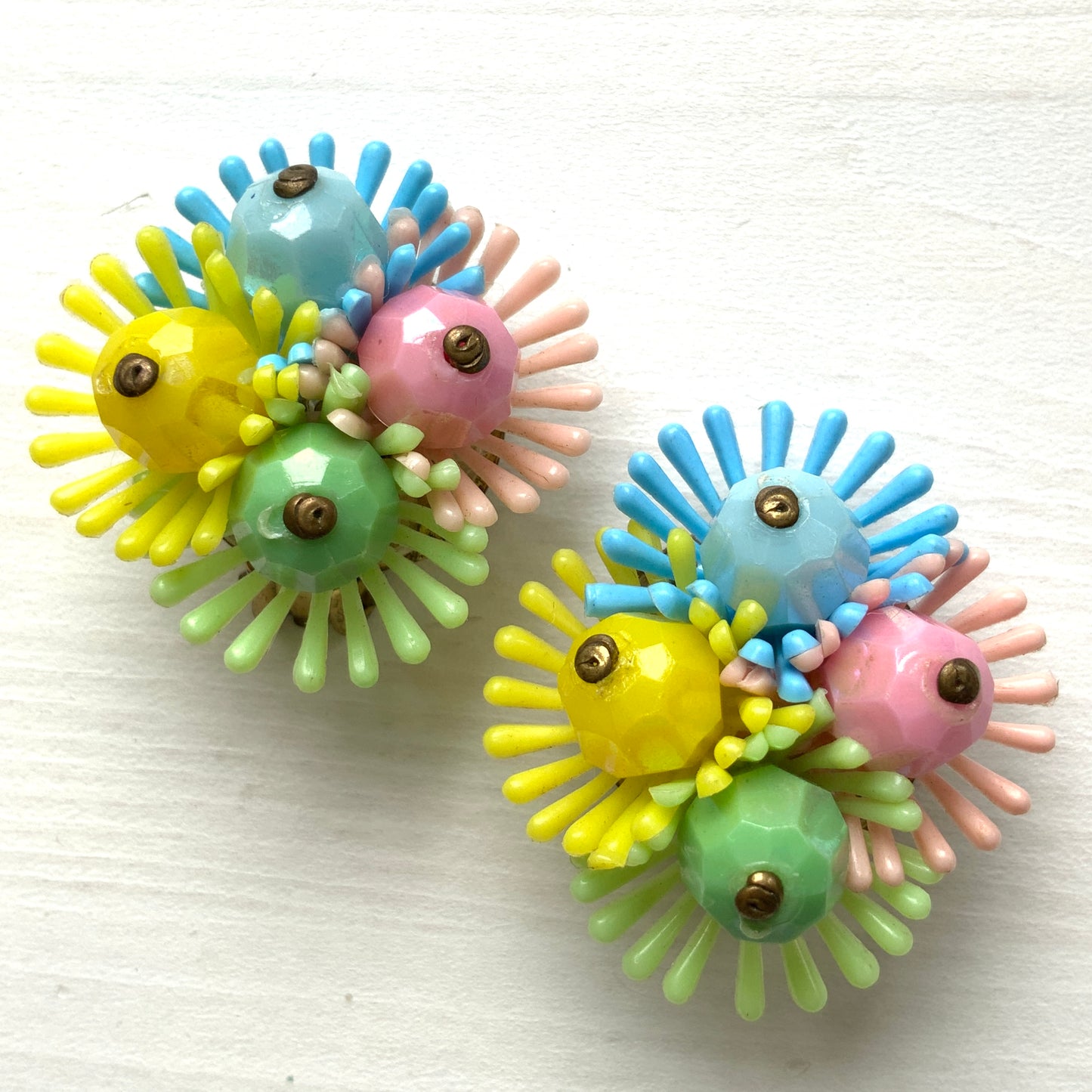 Clip-on earrings featuring clusters of soft plastic flowers in colourful candy hues. カラフルなキャンディーカラーのソフトプラスチックのお花が集まったクリップイヤリング。
