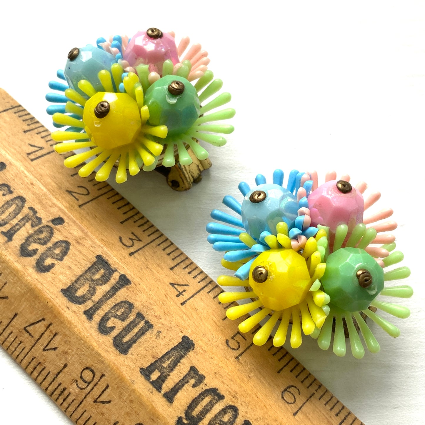 Clip-on earrings featuring clusters of soft plastic flowers in colourful candy hues. カラフルなキャンディーカラーのソフトプラスチックのお花が集まったクリップイヤリング。