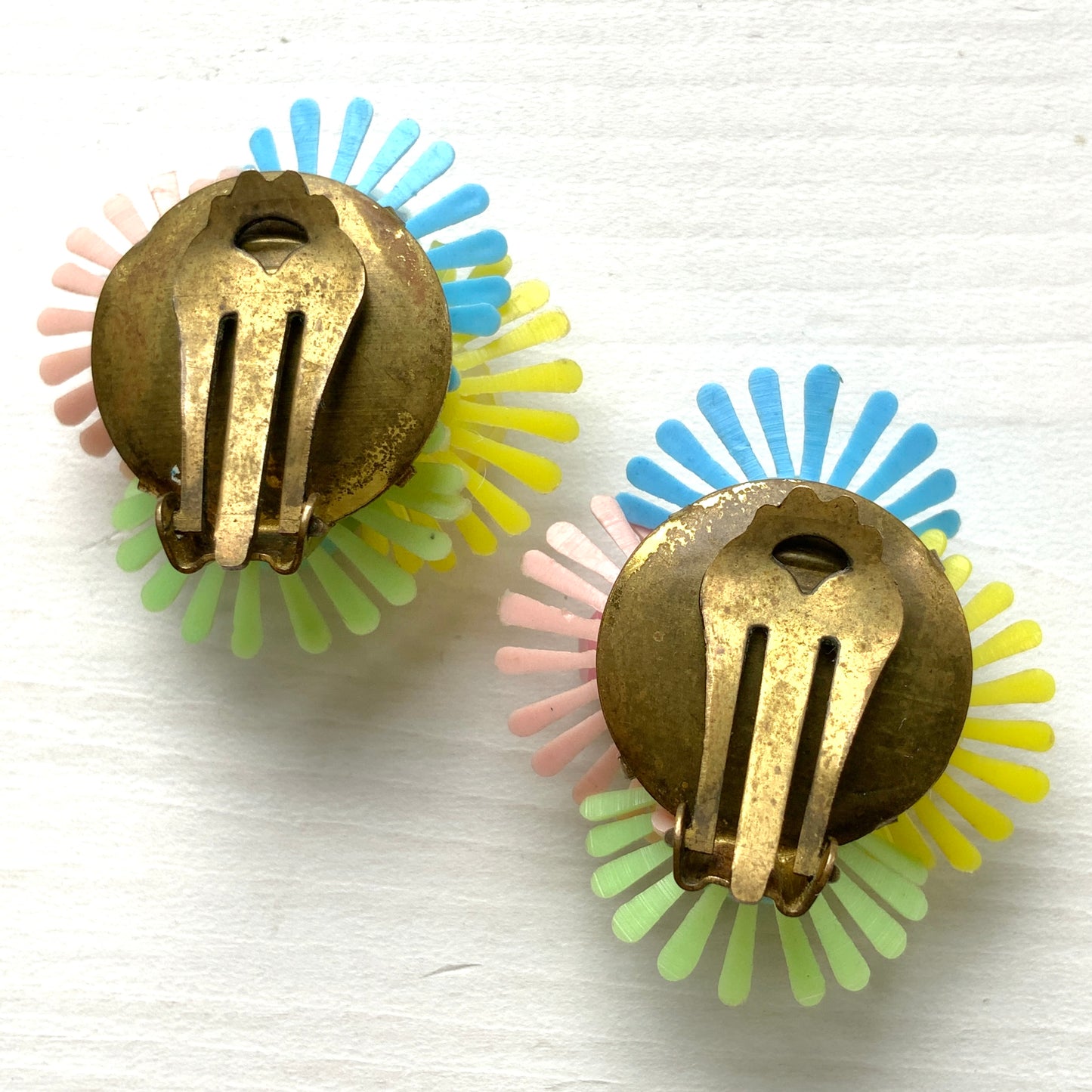 Clip-on earrings featuring clusters of soft plastic flowers in colourful candy hues. カラフルなキャンディーカラーのソフトプラスチックのお花が集まったクリップイヤリング。
