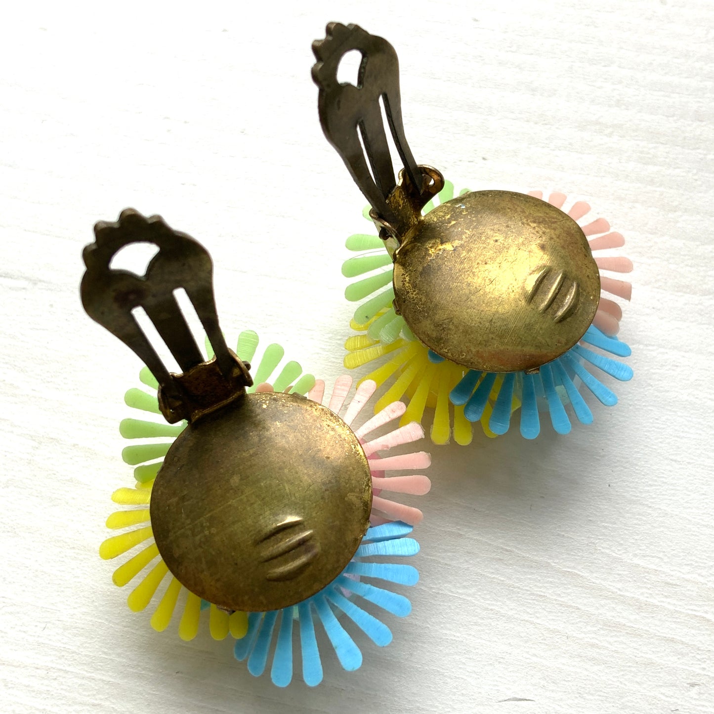 Clip-on earrings featuring clusters of soft plastic flowers in colourful candy hues. カラフルなキャンディーカラーのソフトプラスチックのお花が集まったクリップイヤリング。