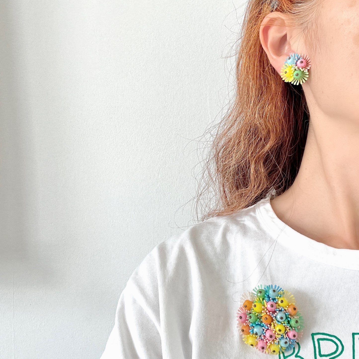 Clip-on earrings featuring clusters of soft plastic flowers in colourful candy hues. カラフルなキャンディーカラーのソフトプラスチックのお花が集まったクリップイヤリング。
