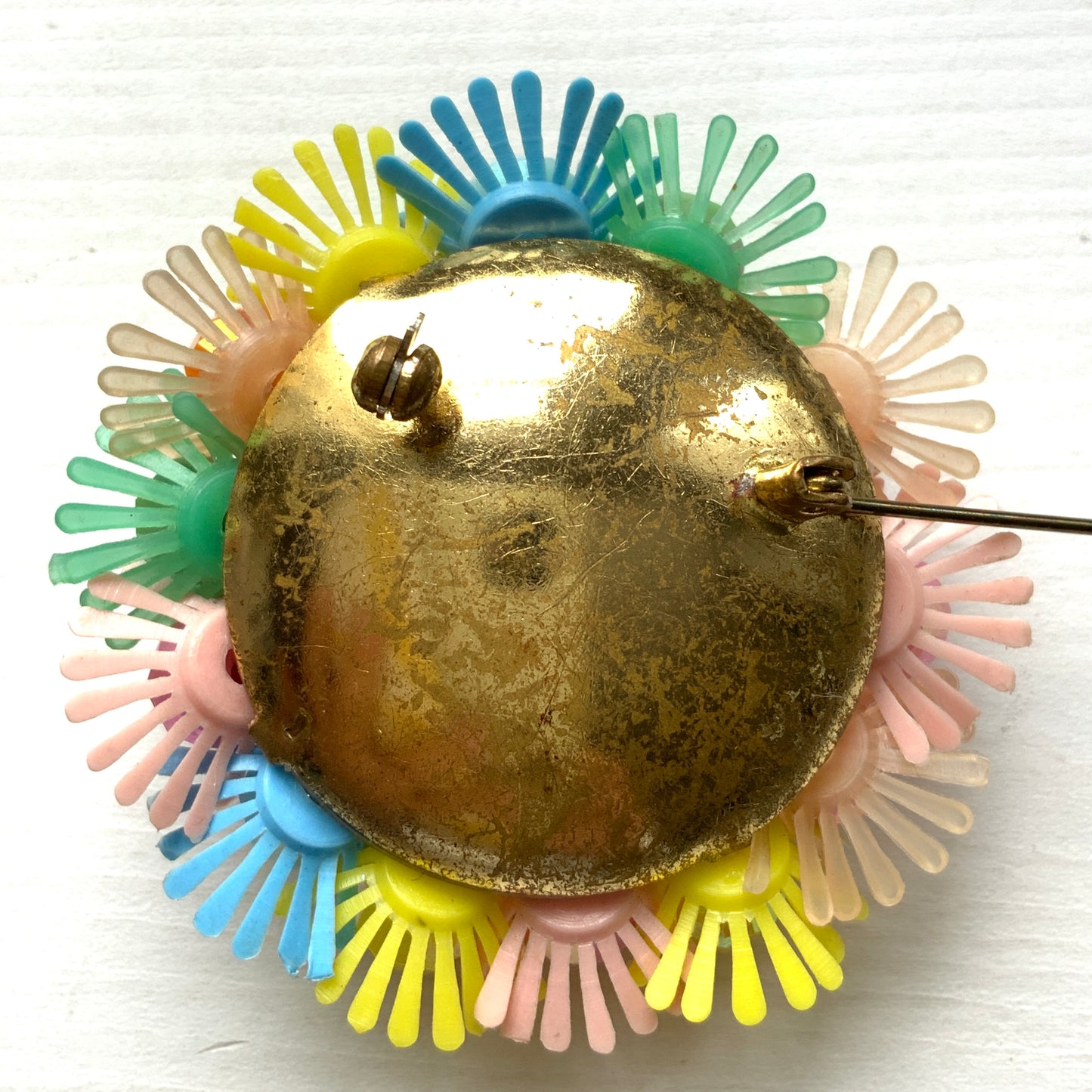 A round brooch featuring colourful candy-coloured soft plastic flowers. カラフルなキャンディーカラーのソフトプラスチックのお花が集まったラウンドブローチ。
