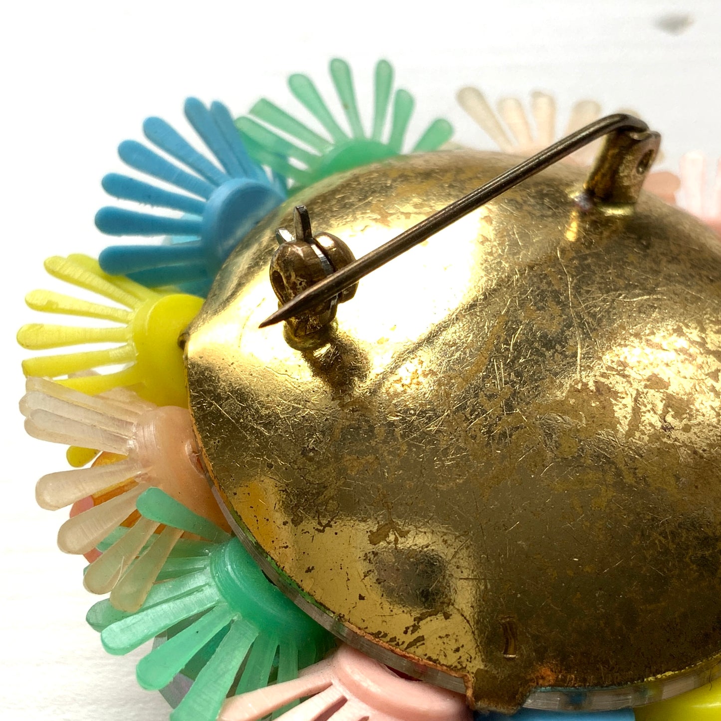 A round brooch featuring colourful candy-coloured soft plastic flowers. カラフルなキャンディーカラーのソフトプラスチックのお花が集まったラウンドブローチ。