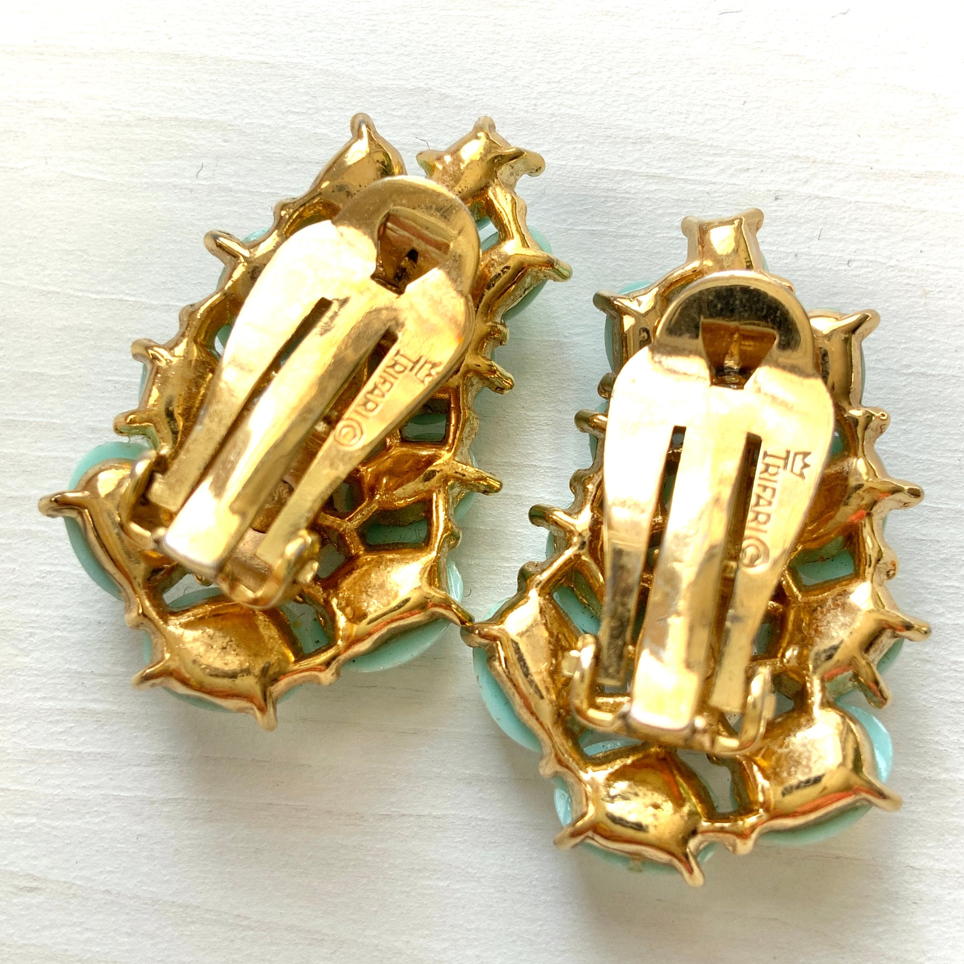 A Trifari dress clip featuring a pure white faux baroque pearl, beautifully framed by pastel turquoise plastic cabochons. ピュアホワイトカラーのフォーバロックパール を、パステルターコイズのプラスチックカボションが囲んでいる、トリファリのドレスクリップ。