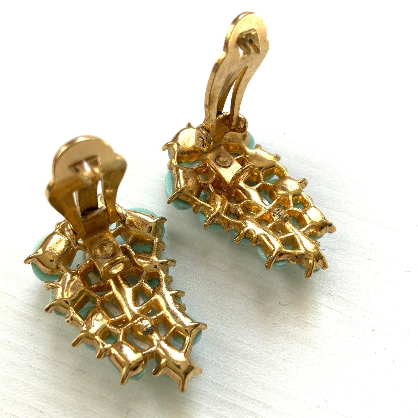 A Trifari dress clip featuring a pure white faux baroque pearl, beautifully framed by pastel turquoise plastic cabochons. ピュアホワイトカラーのフォーバロックパール を、パステルターコイズのプラスチックカボションが囲んでいる、トリファリのドレスクリップ。