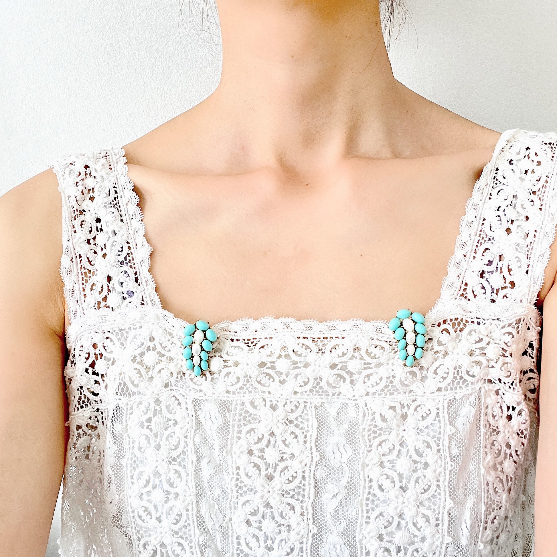 A Trifari dress clip featuring a pure white faux baroque pearl, beautifully framed by pastel turquoise plastic cabochons. ピュアホワイトカラーのフォーバロックパール を、パステルターコイズのプラスチックカボションが囲んでいる、トリファリのドレスクリップ。