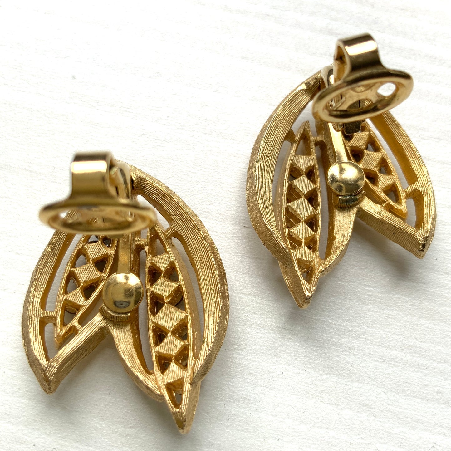 Trifari clip-on earrings featuring slim, bamboo leaf–like gold-tone leaves adorned with a row of blue rhinestones. 笹の葉のようにスリムなゴールドトーンのリーフに、ブルーのラインストーンが並んだトリファリのイヤリング。