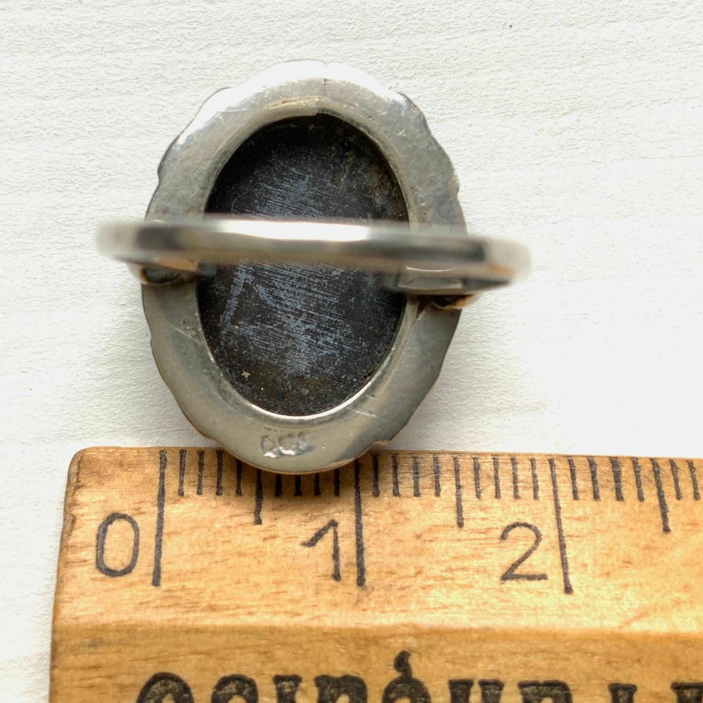 A silver ring with a cameo carved from mother of pearl, featuring the white layer carved into the profile of a lady against an iridescent grey-pink background. 白蝶貝(マザーオブパール)の白い層を彫り出し、グレー〜ピンクがかった虹色の層を背景にしたカメオのシルバーリング。