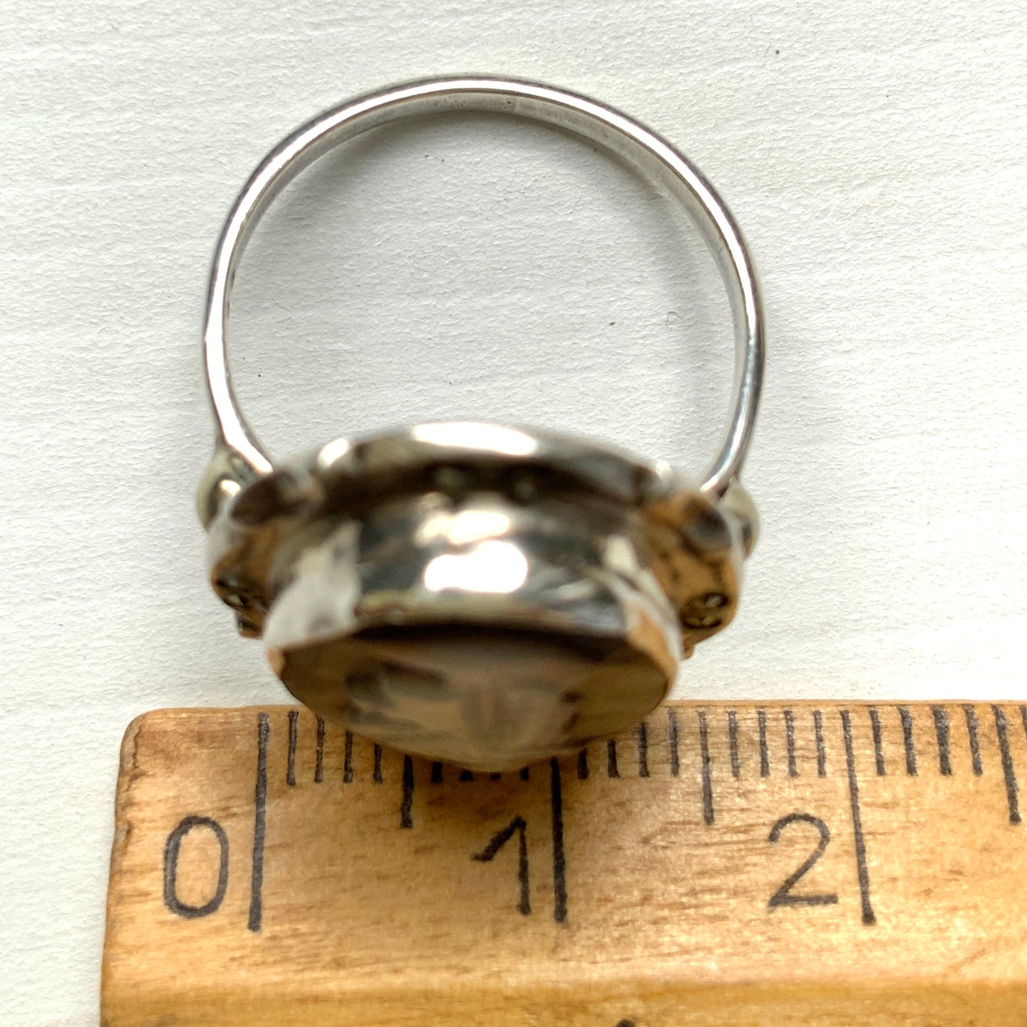 A silver ring with a cameo carved from mother of pearl, featuring the white layer carved into the profile of a lady against an iridescent grey-pink background. 白蝶貝(マザーオブパール)の白い層を彫り出し、グレー〜ピンクがかった虹色の層を背景にしたカメオのシルバーリング。