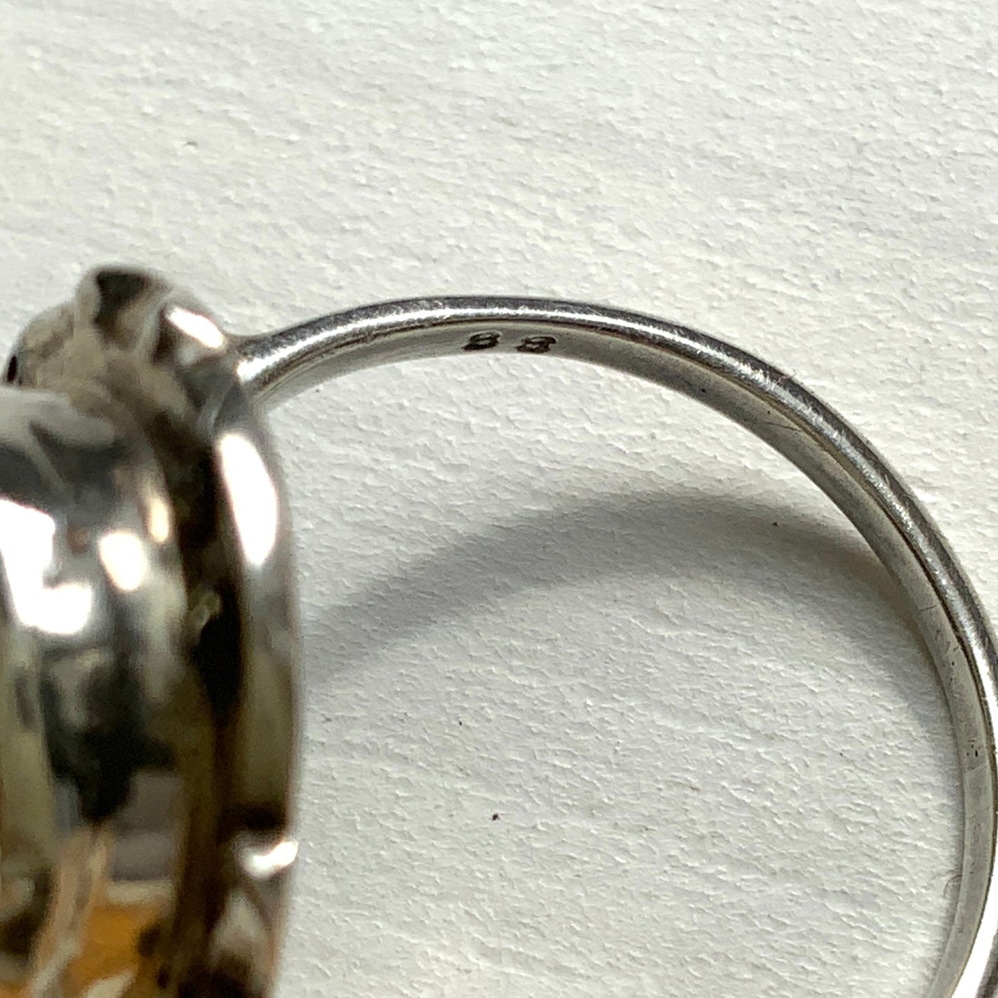 A silver ring with a cameo carved from mother of pearl, featuring the white layer carved into the profile of a lady against an iridescent grey-pink background. 白蝶貝(マザーオブパール)の白い層を彫り出し、グレー〜ピンクがかった虹色の層を背景にしたカメオのシルバーリング。