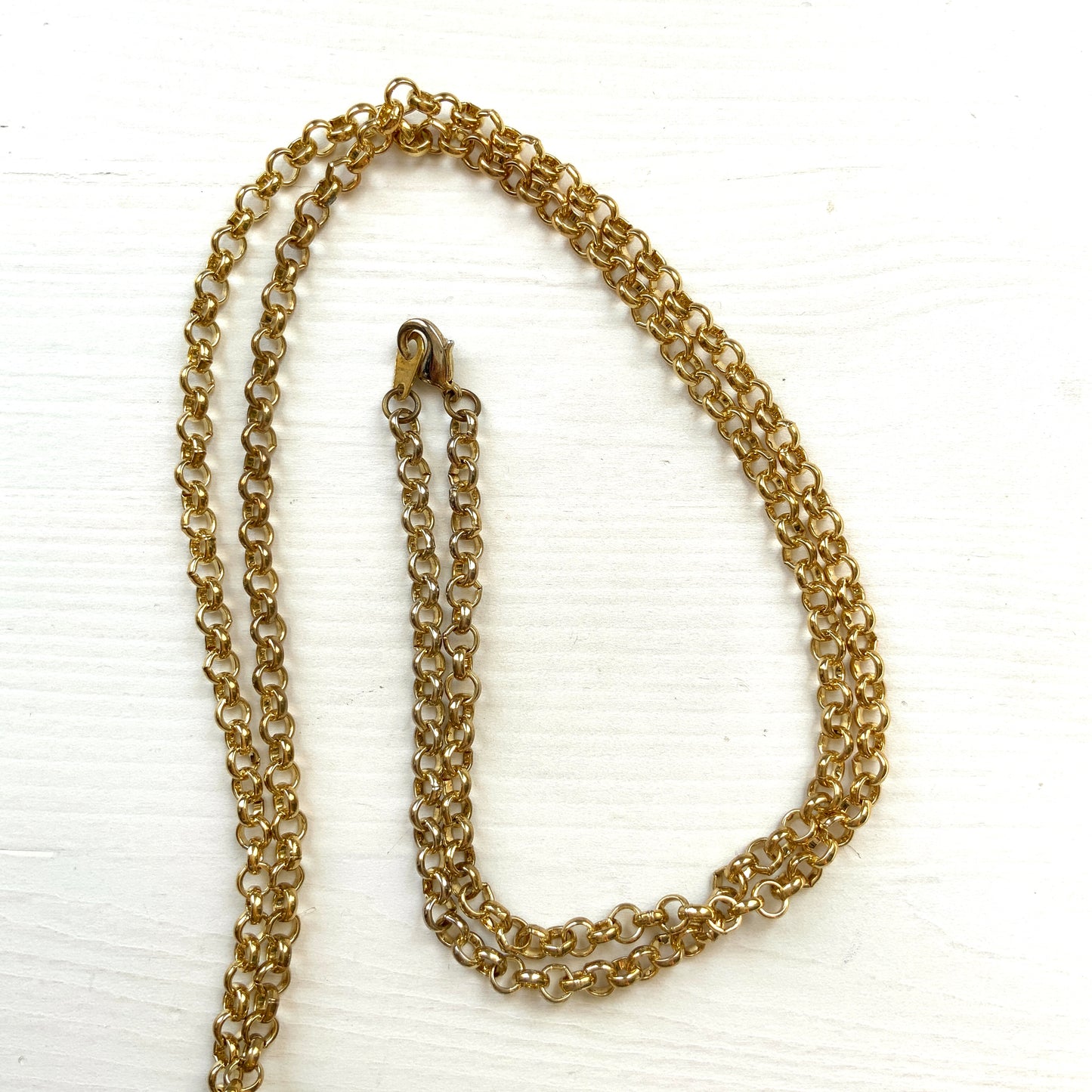 A striking pendant necklace featuring a decorative orb encircled by a metal hoop, resembling the rings of Saturn. カラフルなストーンで飾られた宝珠(キリスト教圏で、十字架をのせた球体として王権の象徴に用いられるモチーフ)を、まるで土星の輪のようなメタルフープで囲んだデザインのペンダントネックレスです。